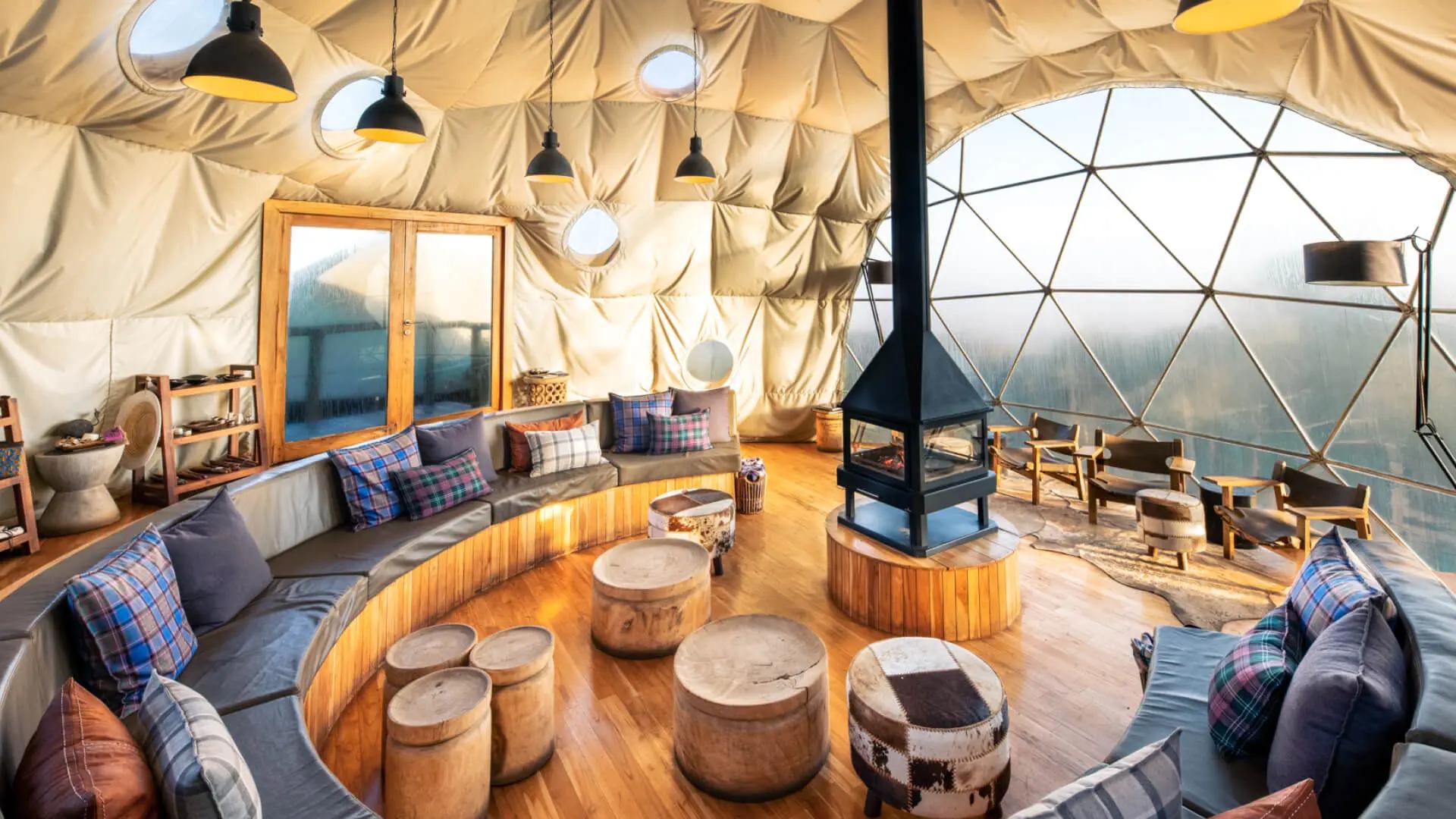 Circular dome lounge with curved sofas and a central stove, The Highlands, Asilia, Ngorongoro Conservation Area, Tanzania