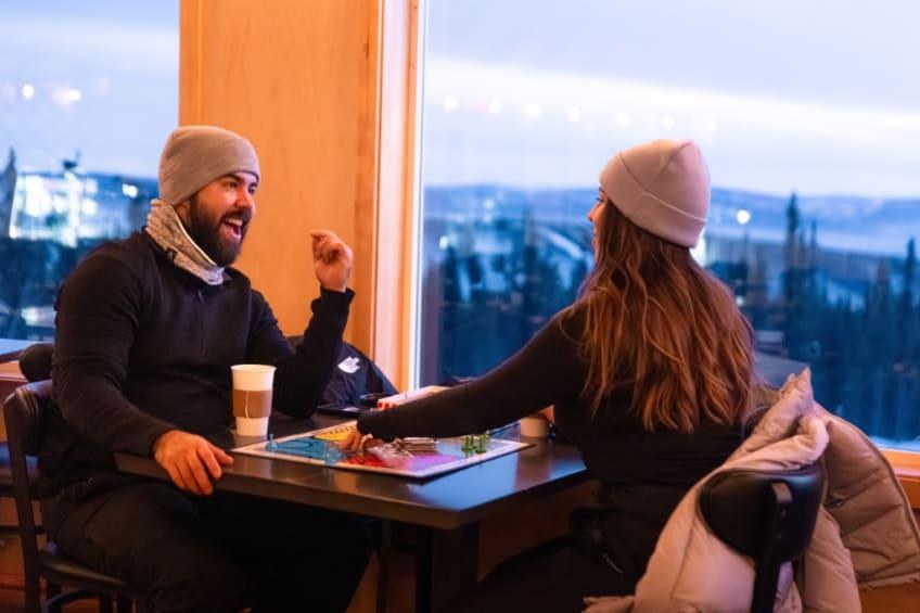 Guests seated beside panoramic windows in the Latitude 65 dining area, Borealis Basecamp, Alaska, USA