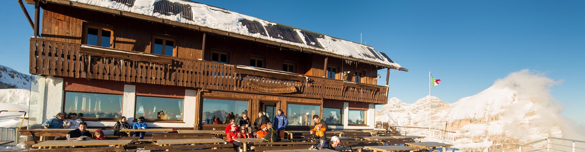 Guests on the sunny terrace of Rifugio Lagazuoi in winter, Dolomites, Italy