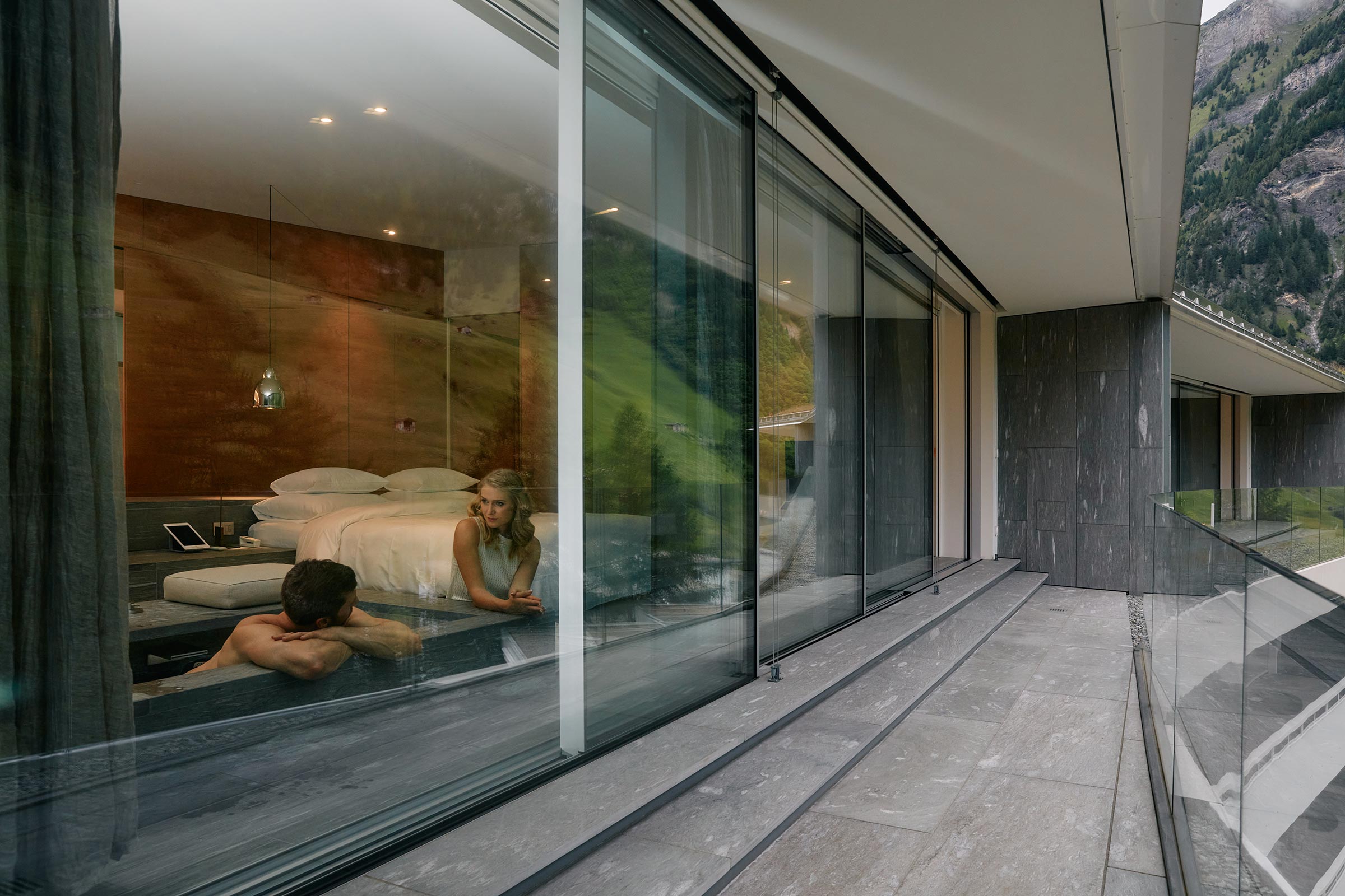 Stone terrace and glazed facade of a 7132 Hotel penthouse, Vals, Switzerland