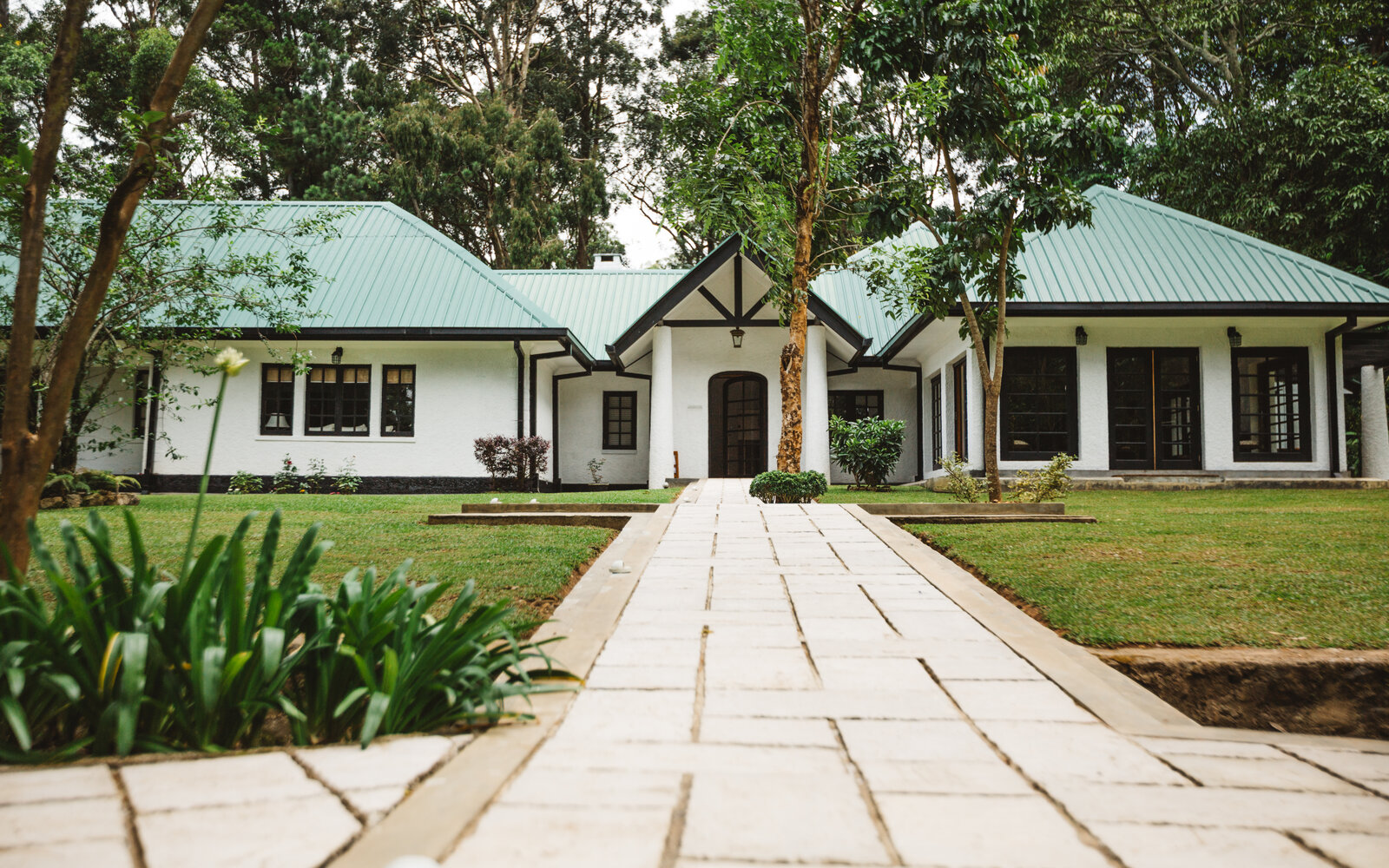 Thotalagala tea planter’s bungalow with green roofs and a garden lawn in Haputale, Sri Lanka
