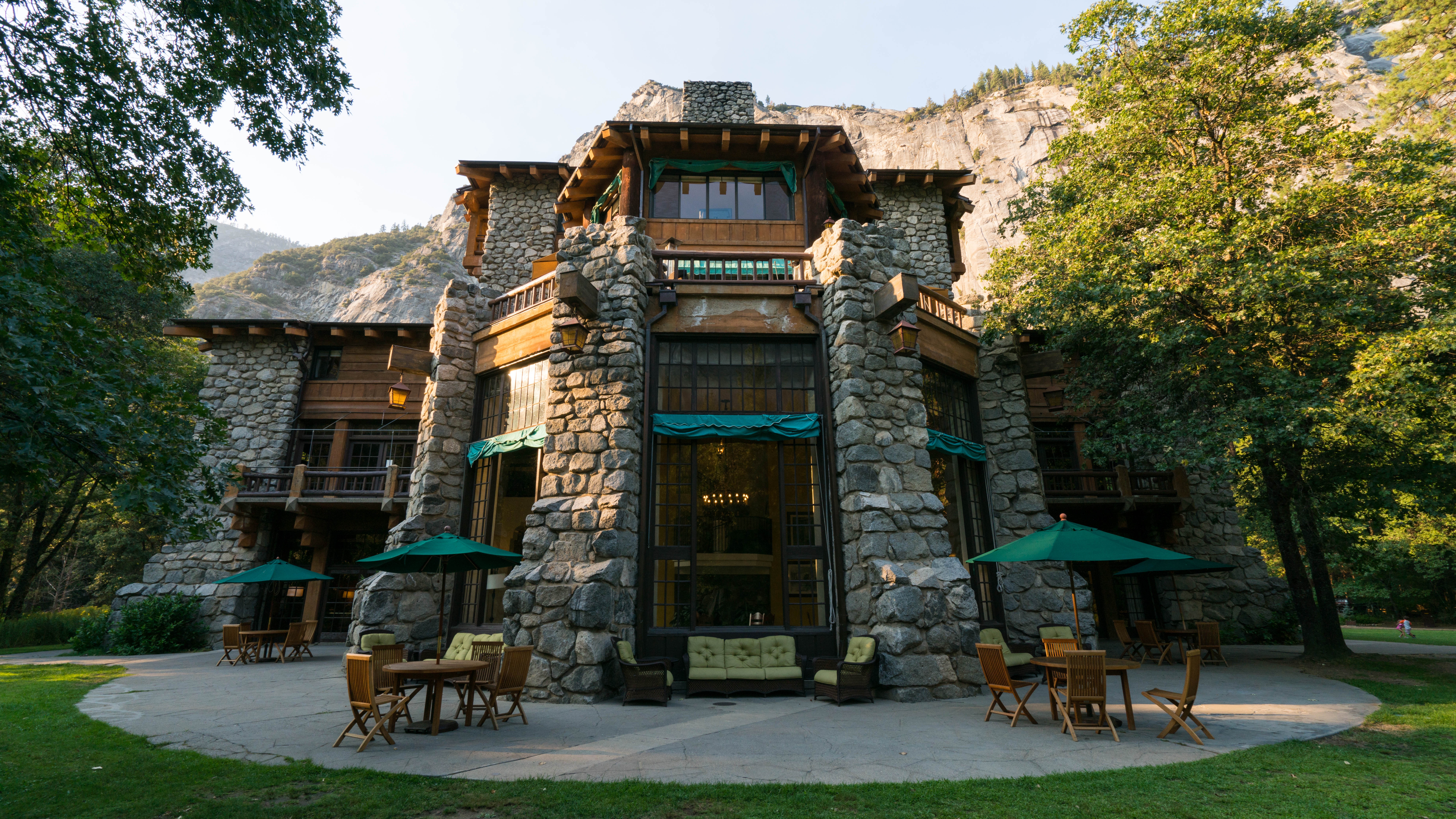Stone hotel entrance surrounded by trees at The Ahwahnee, Yosemite National Park, USA