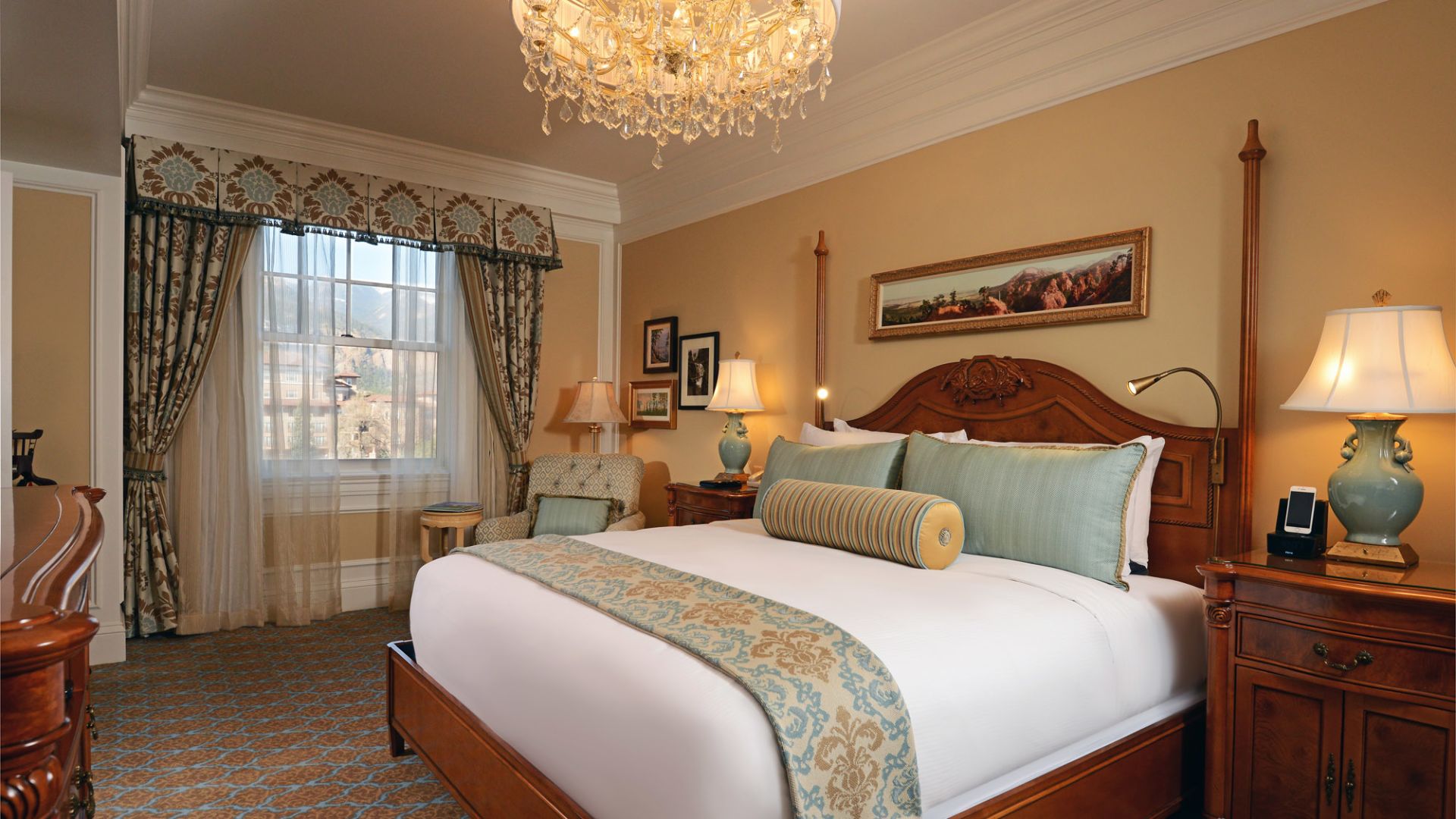 Elegant guest bedroom with a chandelier, bedside lamps, and a large bed at The Broadmoor, Colorado Springs, USA
