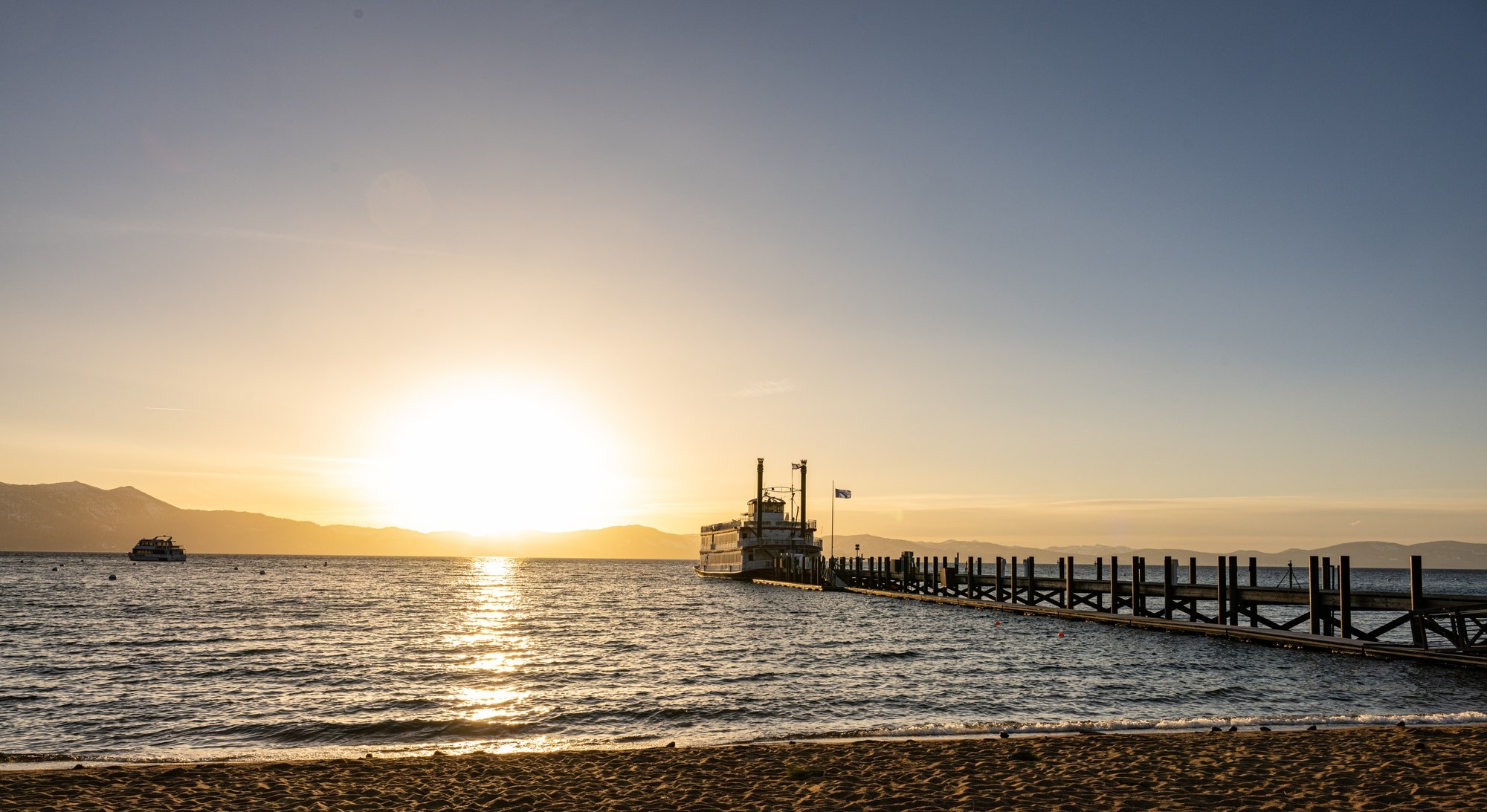 Sunset over the lake beside the pier and boat at Zephyr Cove Resort, Zephyr Cove, USA