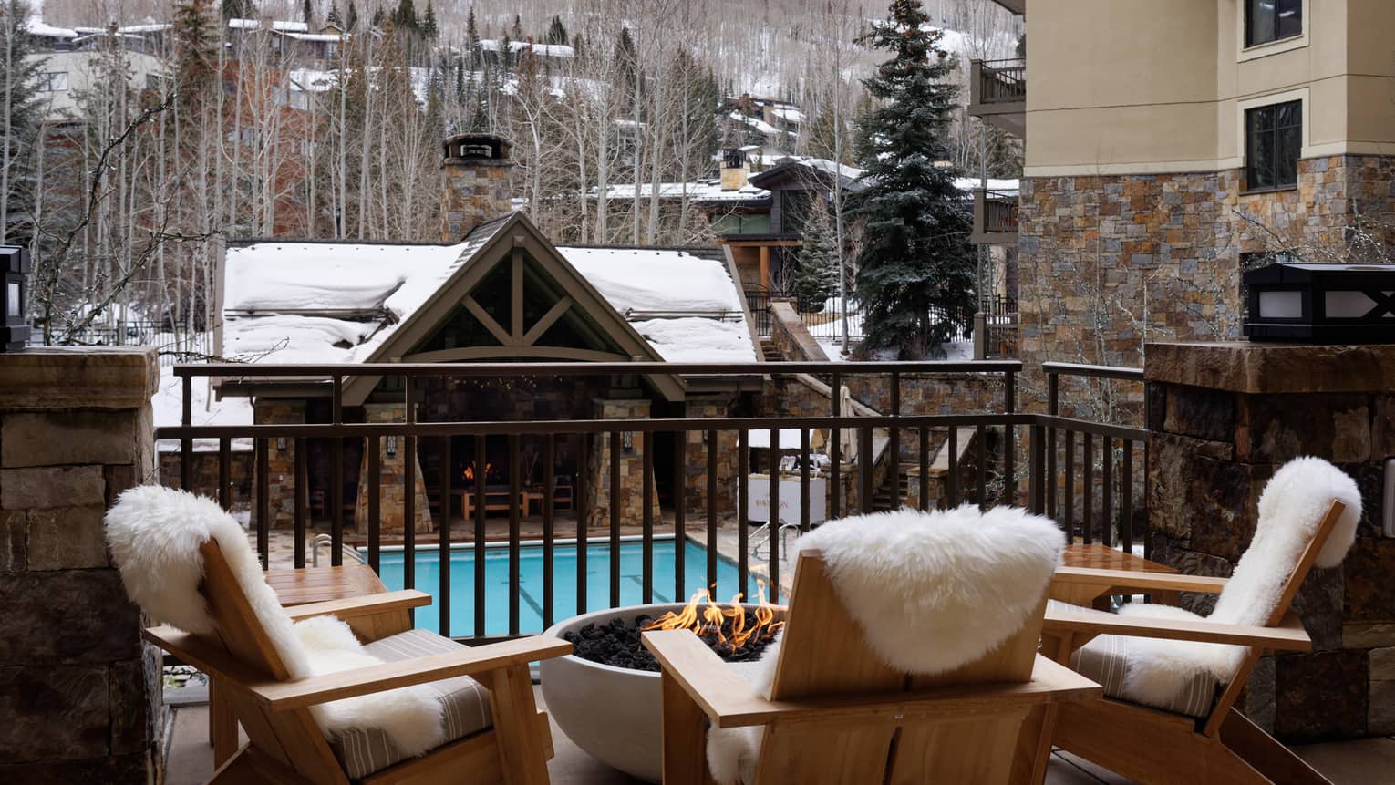 Snow-covered poolside terrace seating overlooking the pool at Four Seasons Resort Vail.