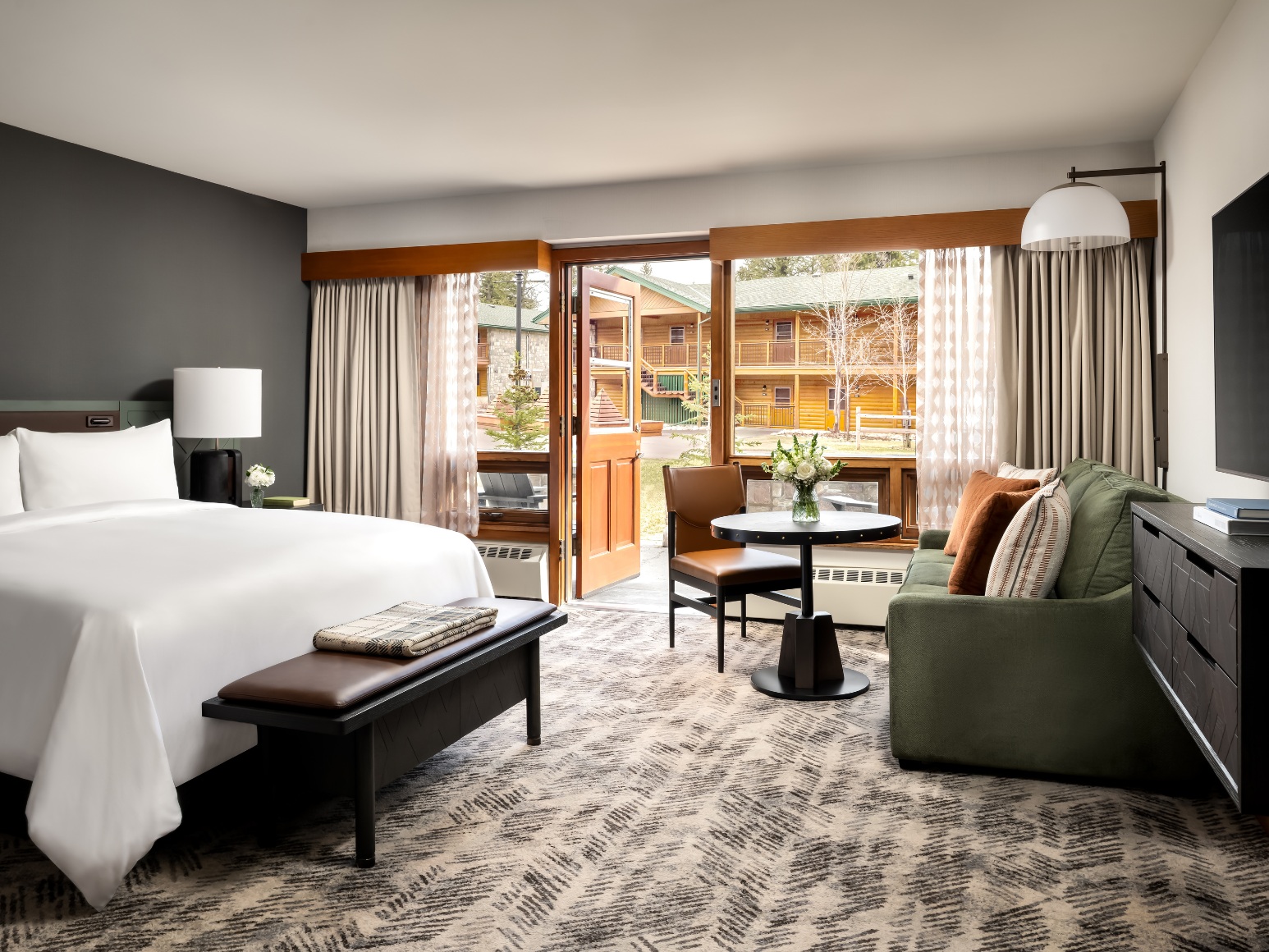 King guest room with seating and large windows at Fairmont Jasper Park Lodge, Jasper, Canada