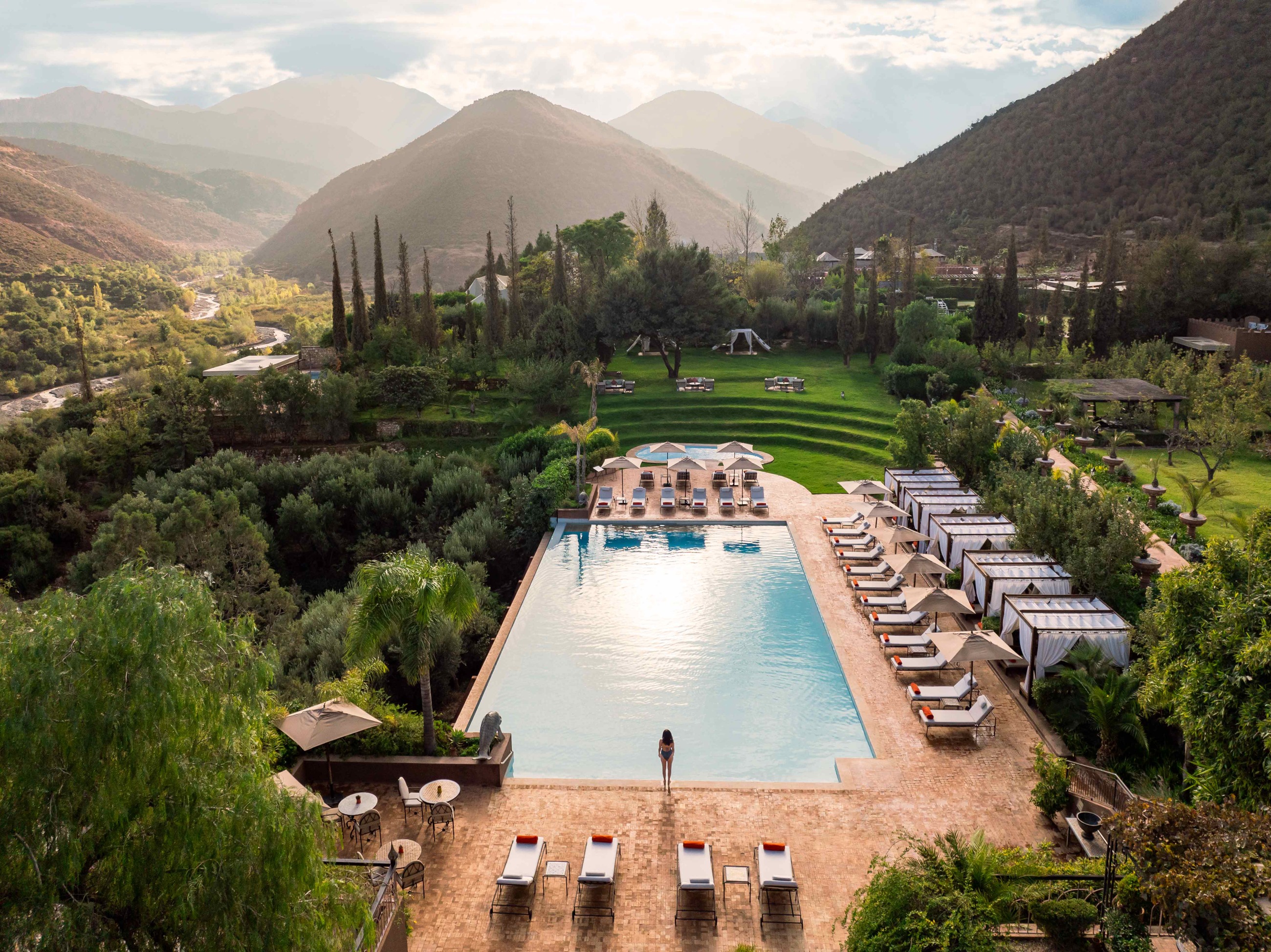 Elevated view of the infinity pool, gardens and High Atlas Mountains at Kasbah Tamadot, Atlas Mountains, Morocco