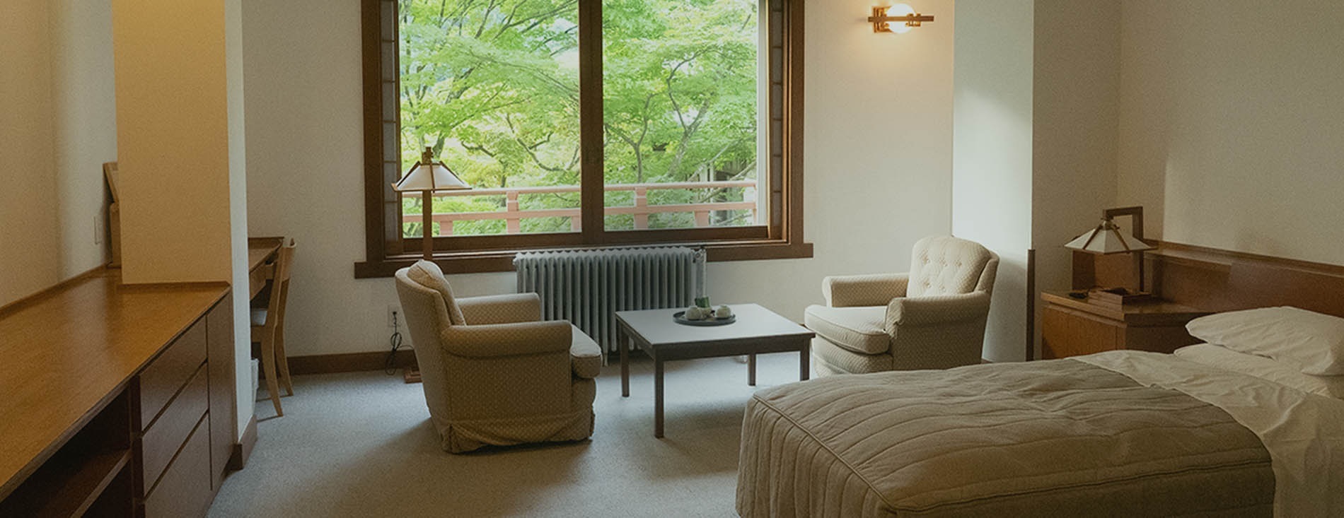 Guest room with seating beside a large window at Nikko Kanaya Hotel, Nikko, Japan