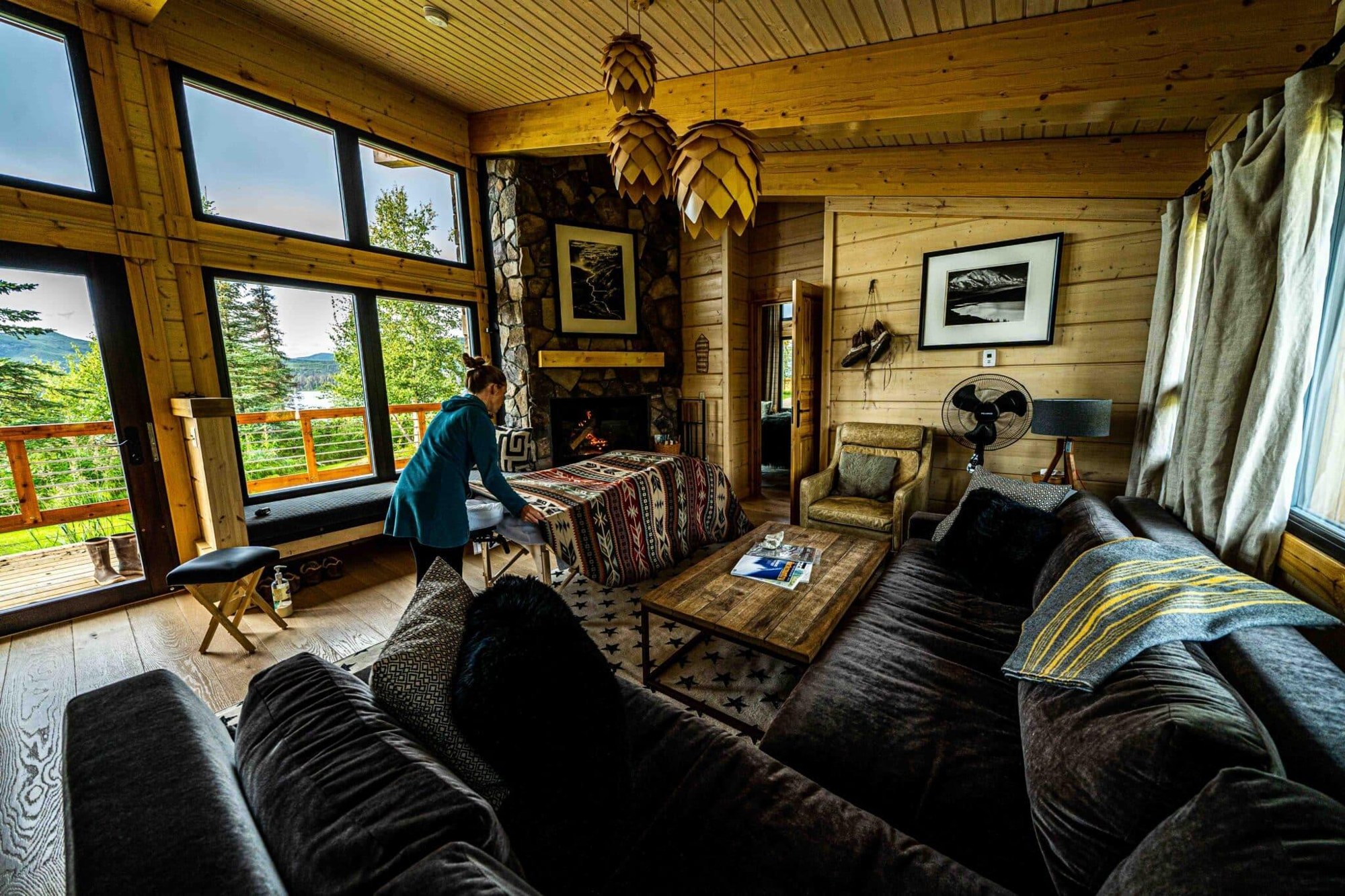 Timber lodge lounge with leather sofas and a wood stove, Tordrillo Mountain Lodge, Alaska, USA