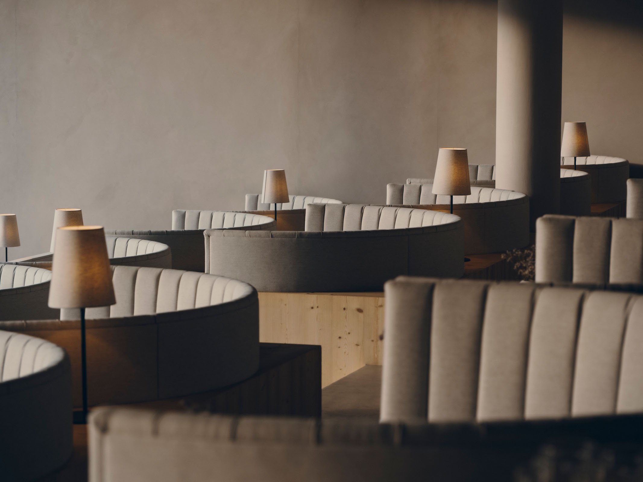 The FORESTIS restaurant dining room with tables, upholstered chairs, and pendant lighting, Dolomites, Italy