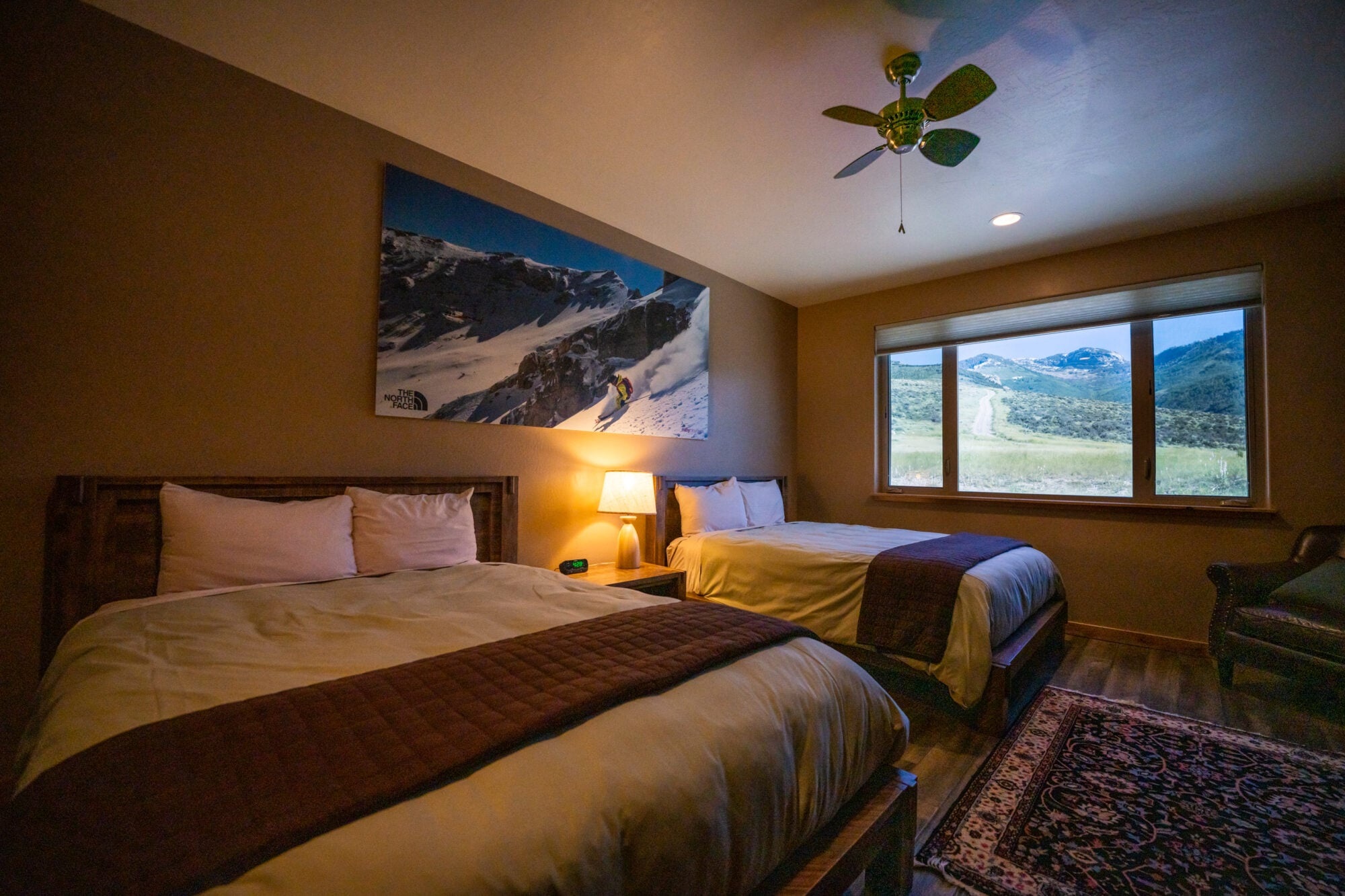 Guest bedroom with two beds and a landscape-view window at Ruby 360 Lodge, Lamoille, USA