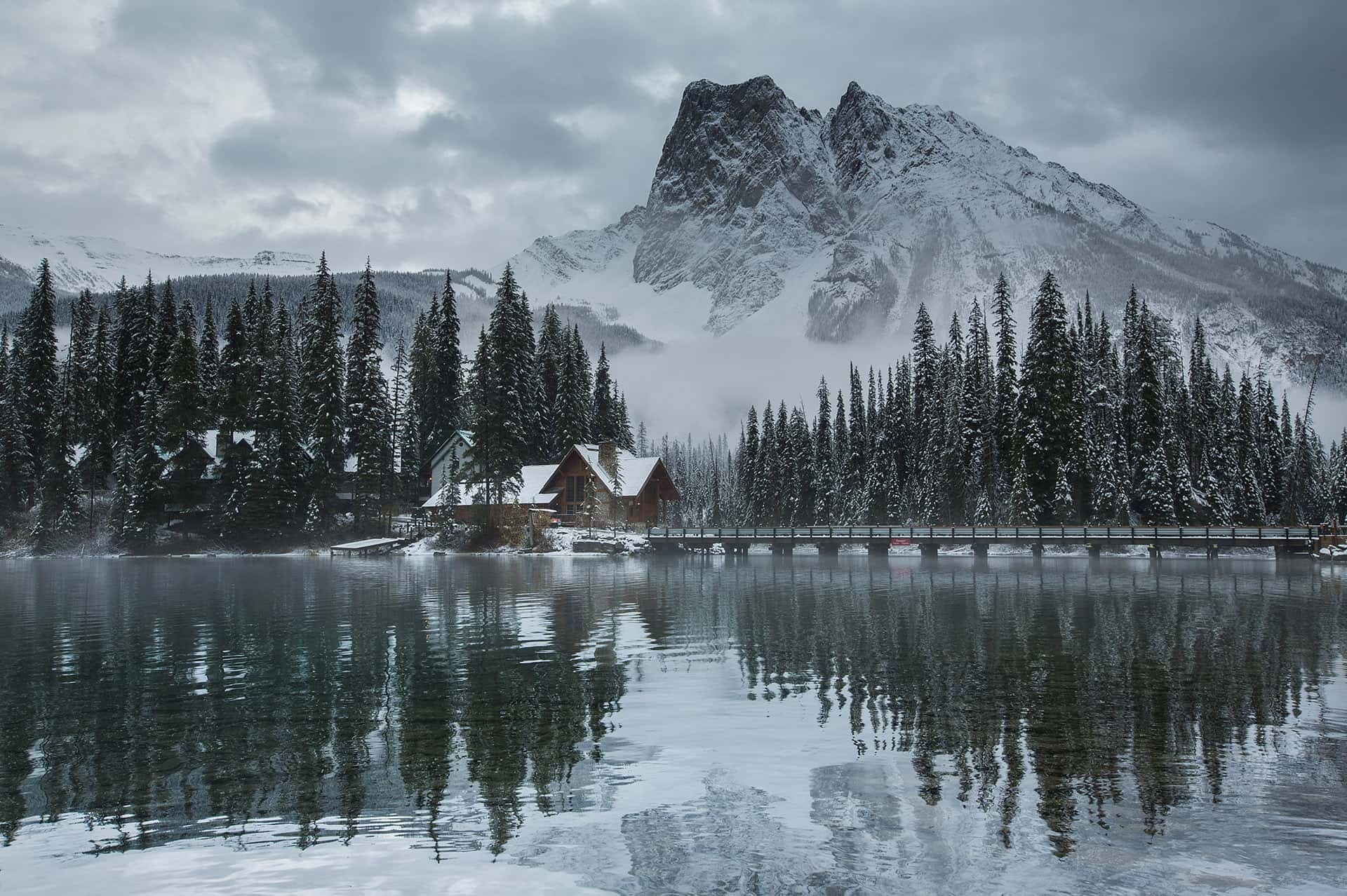 Snowy lakeshore buildings and mountain reflections, Yoho National Park, Canada