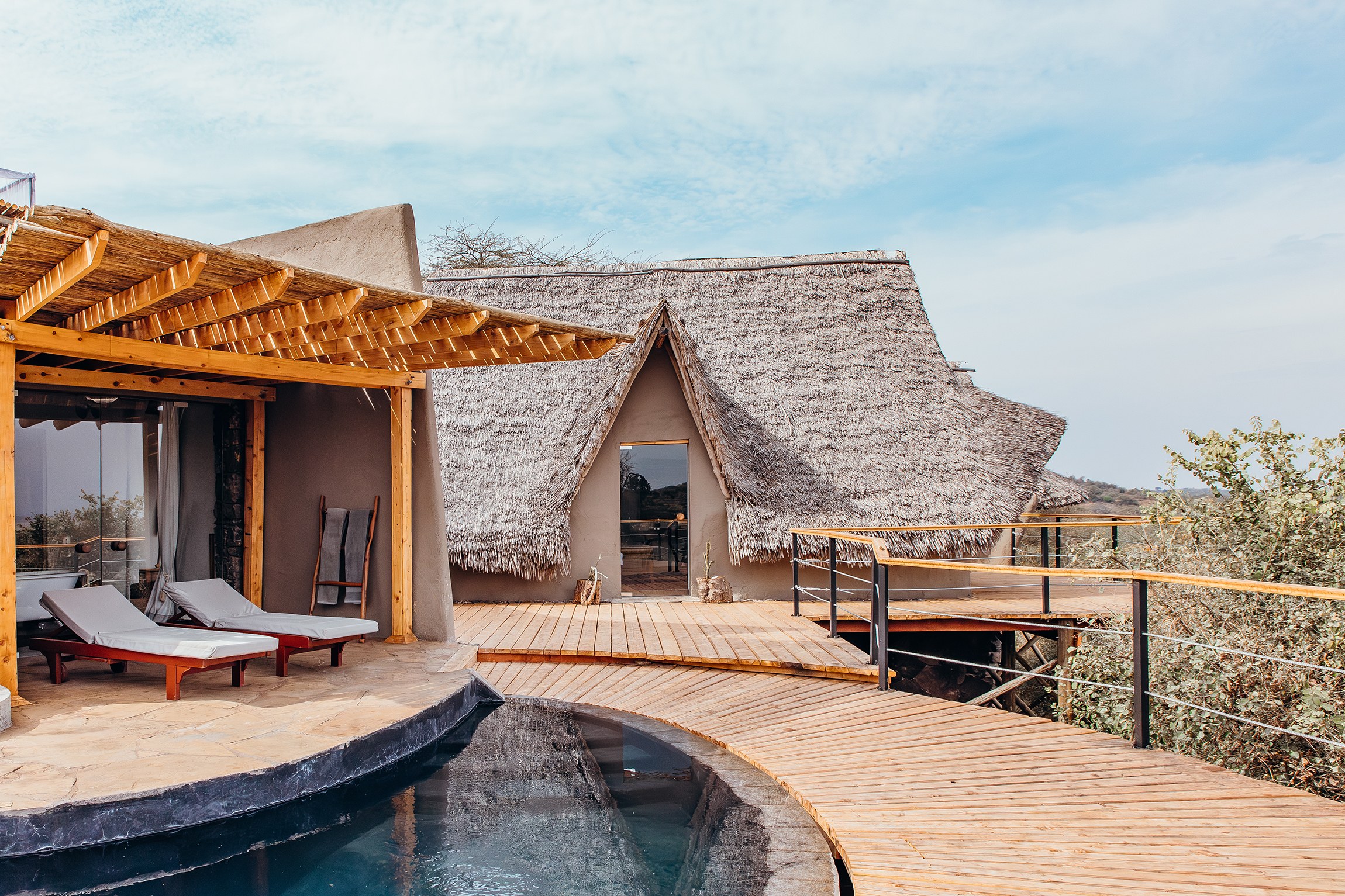 Curved private pool and timber deck outside a thatched suite at Ol Donyo Lodge.