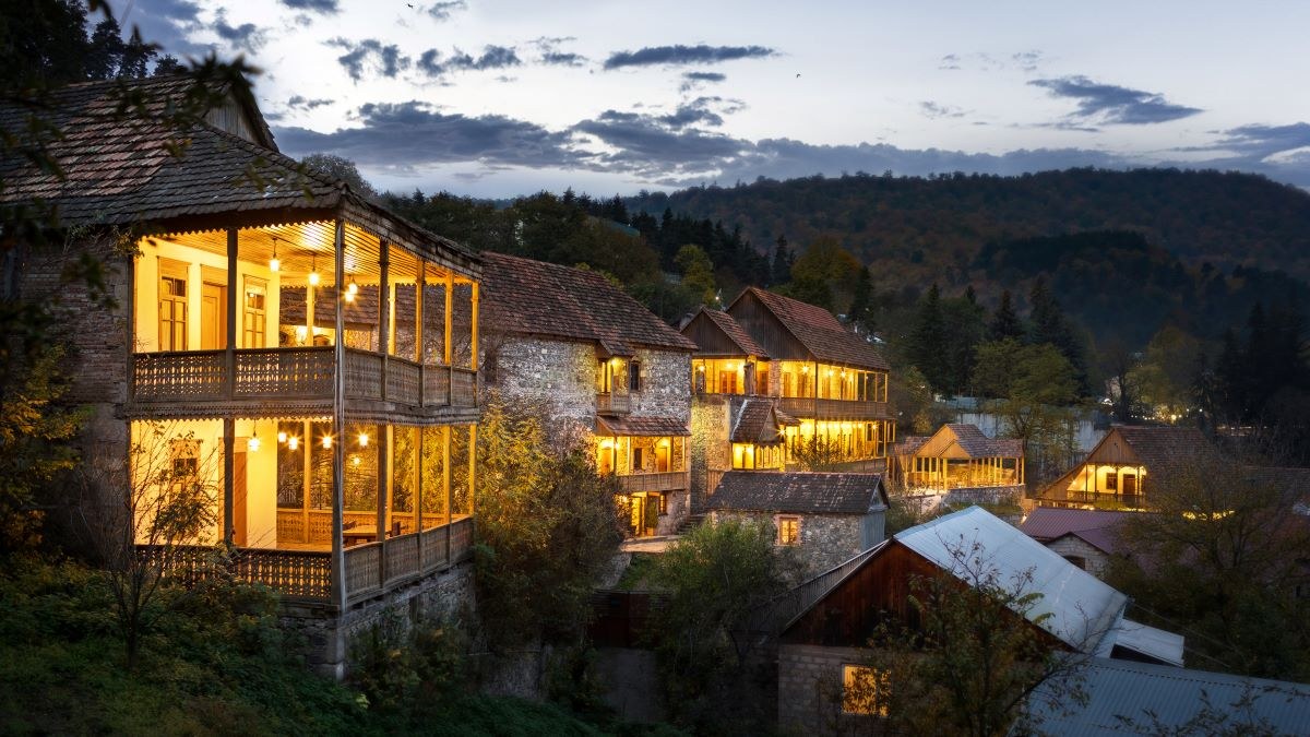 Illuminated wooden balconies at Tufenkian Old Dilijan Complex at dusk