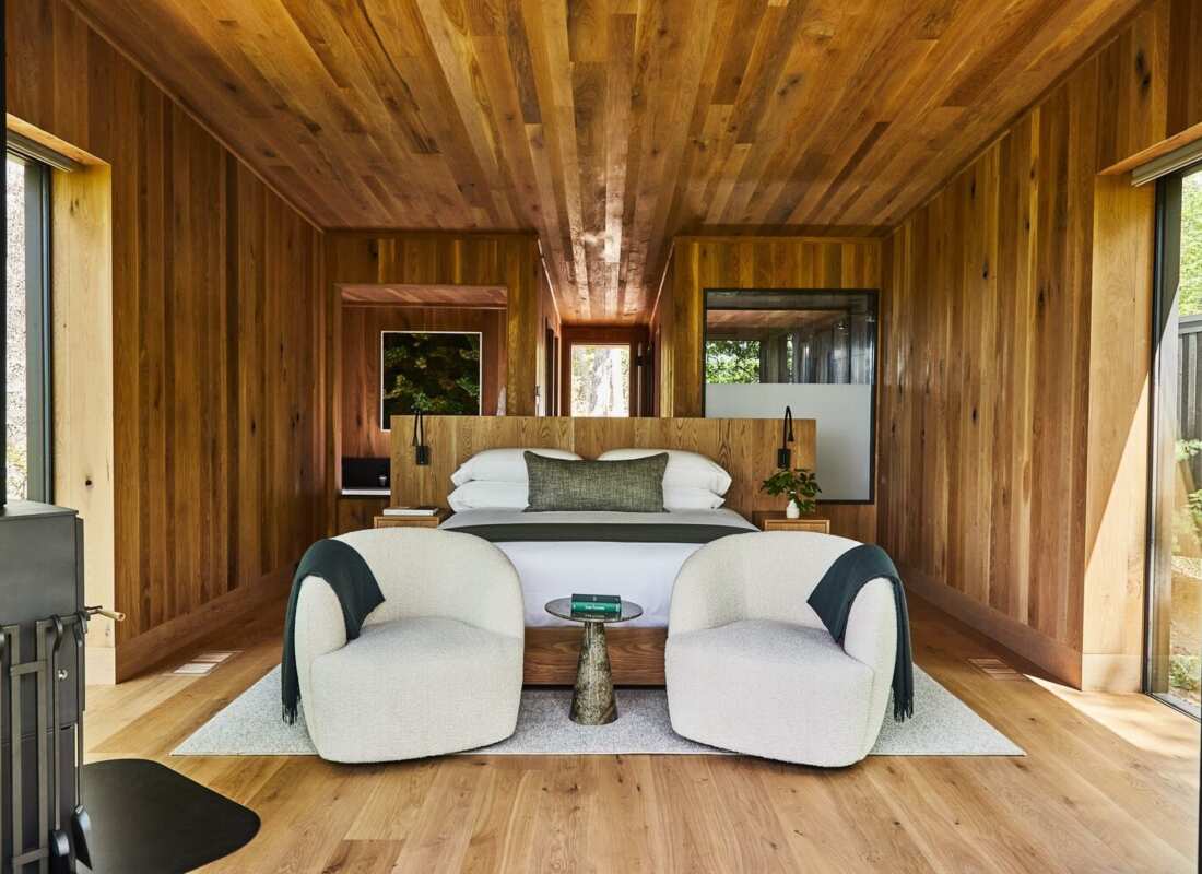 Wood-panelled treehouse bedroom with a king bed and floor-to-ceiling windows at Blackberry Mountain, Walland, USA