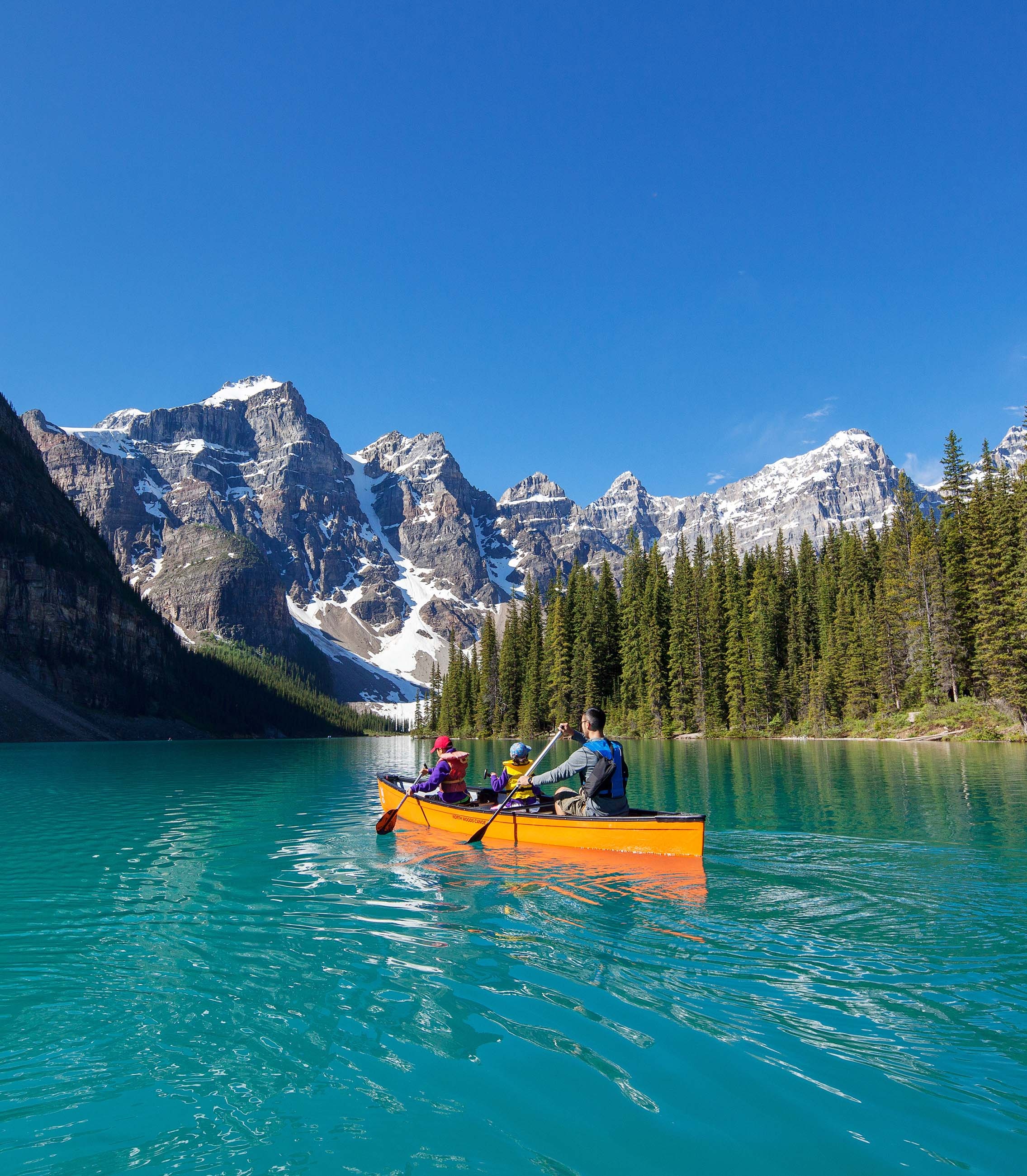 Canoe on turquoise Moraine Lake beneath mountain peaks