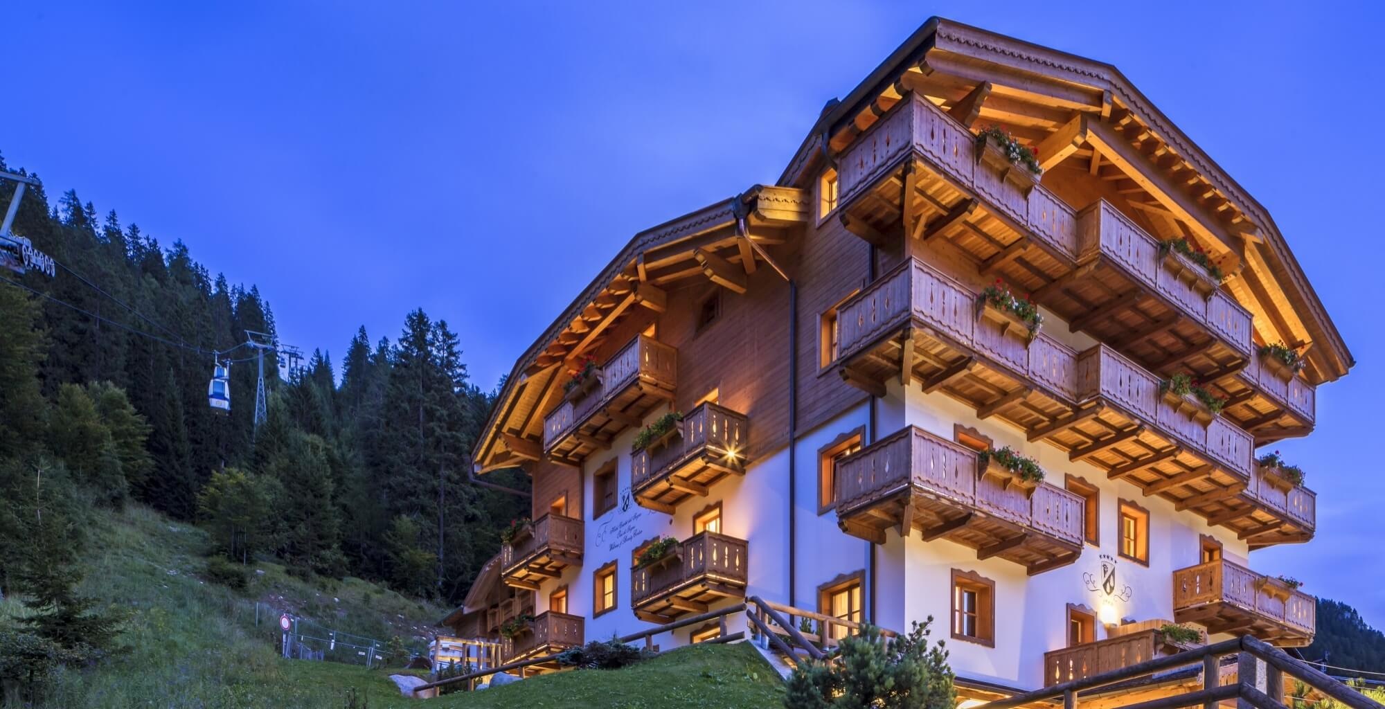 Chalet-style hotel exterior illuminated at dusk, Madonna di Campiglio, Italy