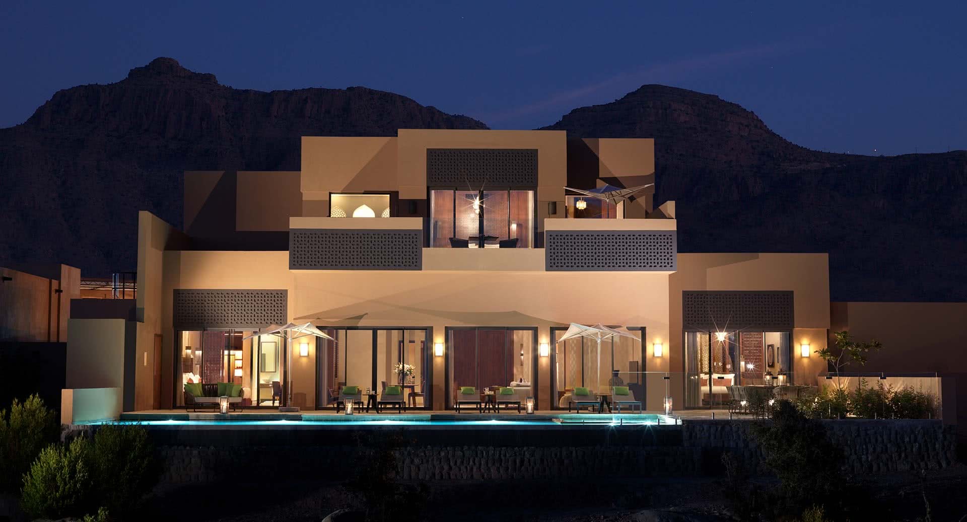 Illuminated villa exterior and pool beneath a mountain ridge, Anantara Al Jabal Al Akhdar, Jebel Akhdar, Oman