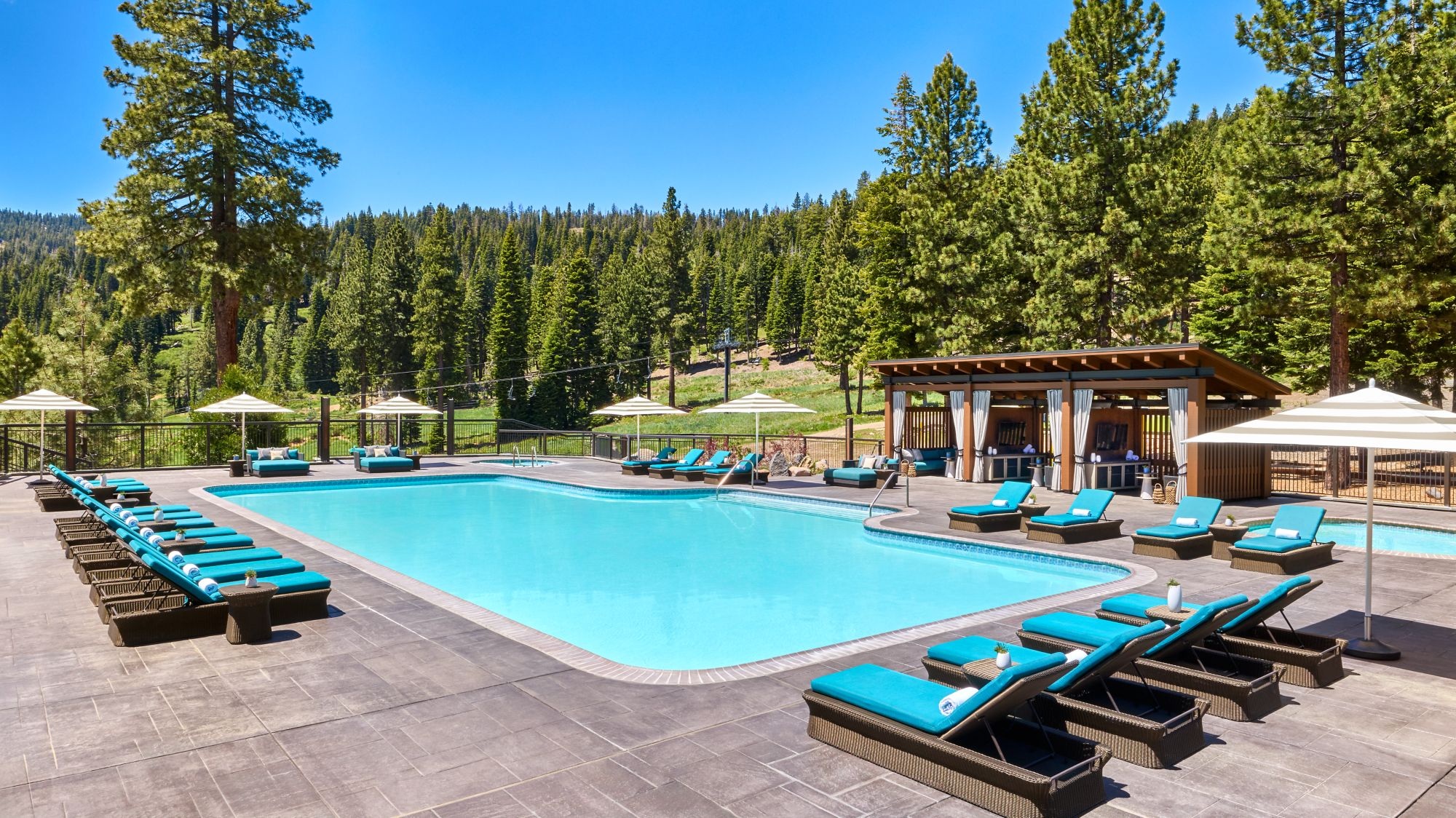 Outdoor pool with loungers and surrounding pine trees at The Ritz-Carlton, Lake Tahoe, Northstar, USA