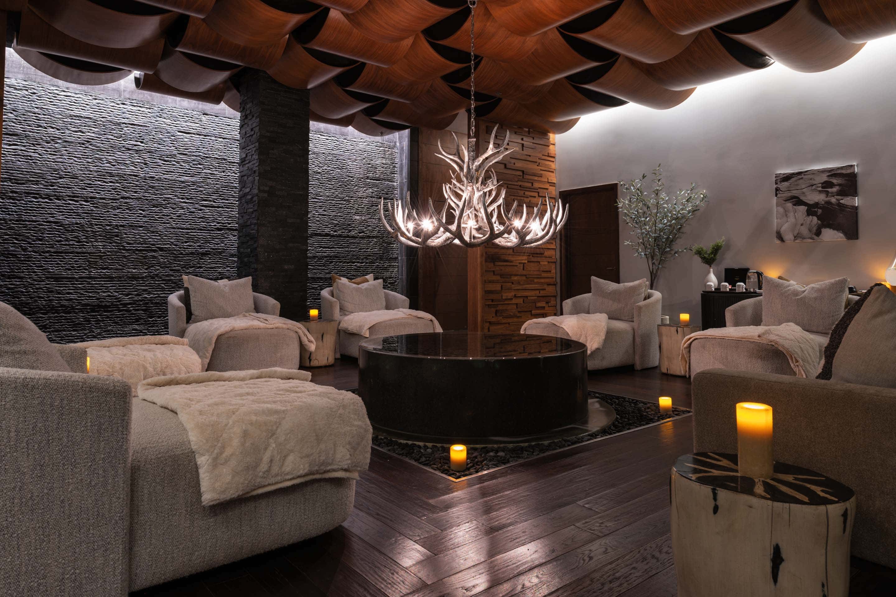 Sculptural chandelier and cushioned seating in the spa relaxation lounge at Viceroy Snowmass.
