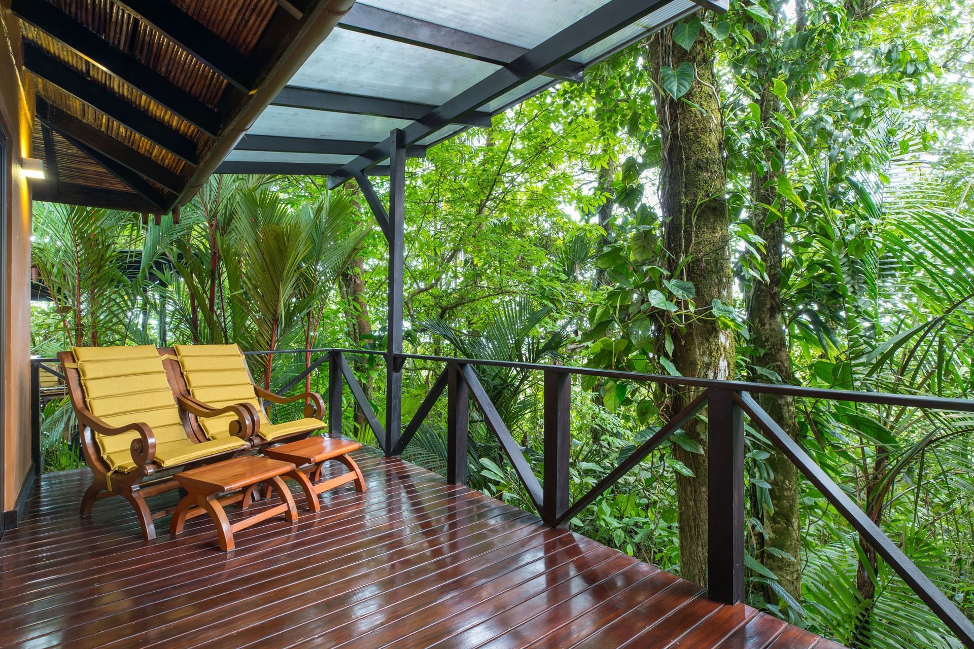 Wooden rocking chairs on a rainforest-facing terrace, Hideaway Rio Celeste, Tenorio, Costa Rica