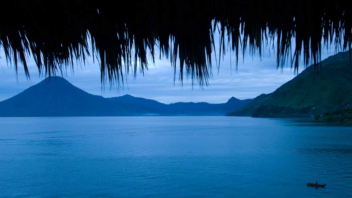 Blue twilight lake view framed by a thatched roof, Laguna Lodge, Lake Atitlán, Guatemala