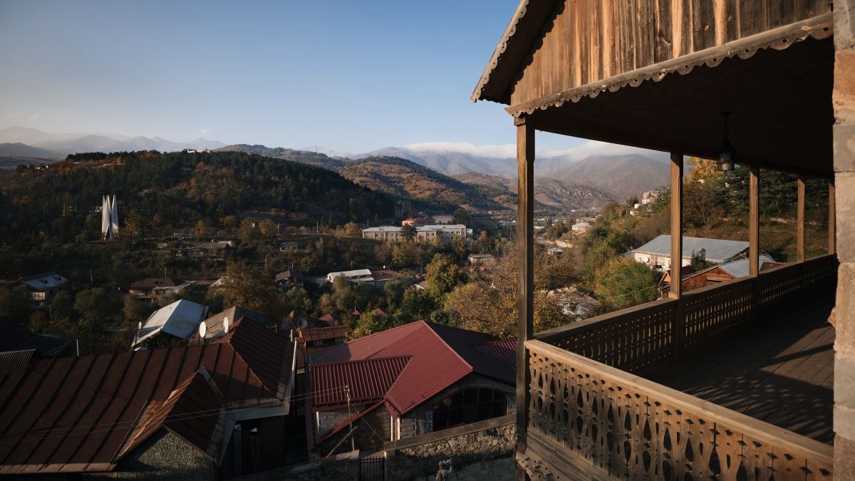 View from a wooden balcony over Dilijan rooftops and wooded hills