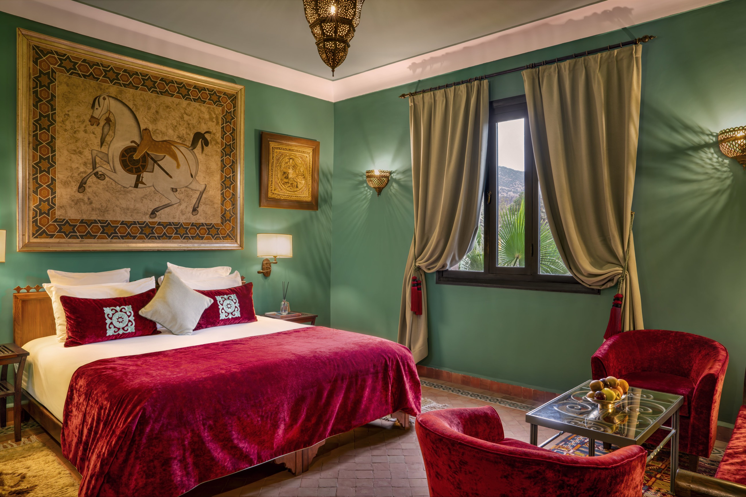 Moroccan guest room with green walls and antique furnishings at Kasbah Tamadot, Atlas Mountains, Morocco
