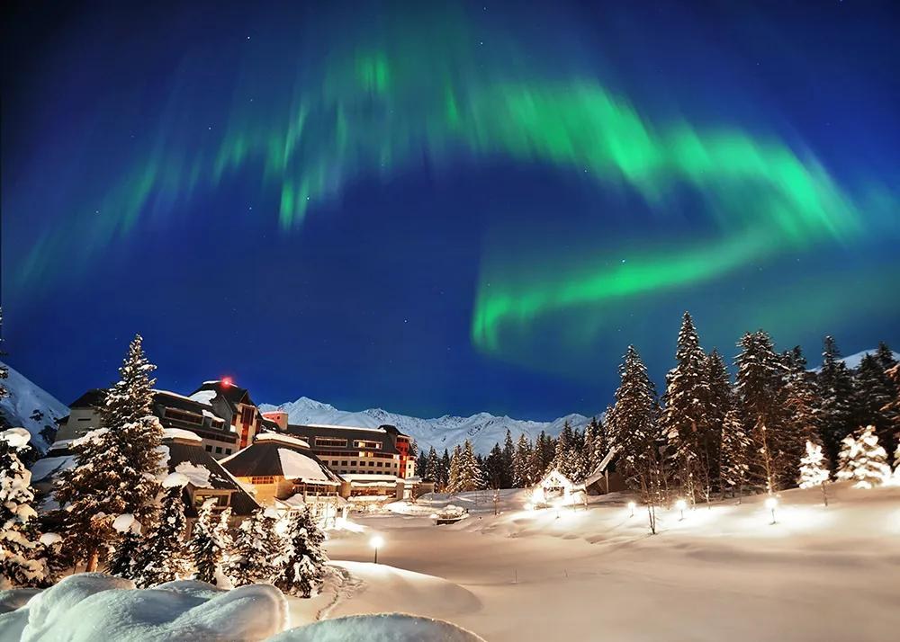 Northern lights above the snow-covered resort hotel, Alyeska Resort, Alaska, USA