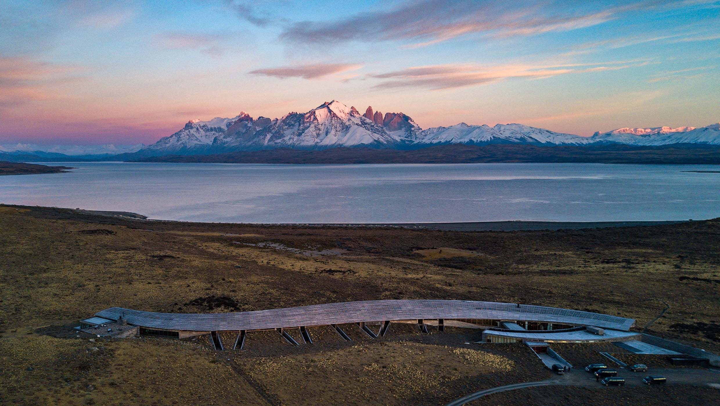 Aerial hotel view beside the lake with mountains in the distance at Tierra Patagonia, Torres del Paine, Chile