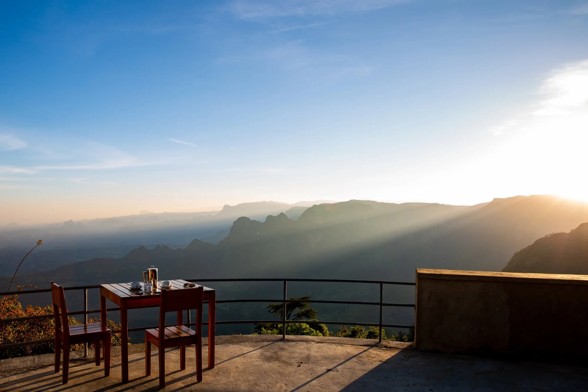 Terrace table and chairs overlooking the Simien escarpment in low evening light, Limalimo Lodge