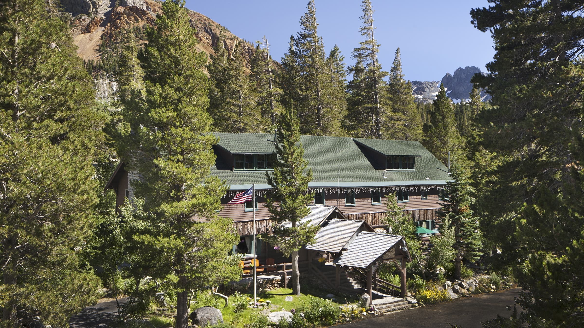 Lodge exterior among pine trees in summer at Tamarack Lodge & Resort, Mammoth Lakes, USA