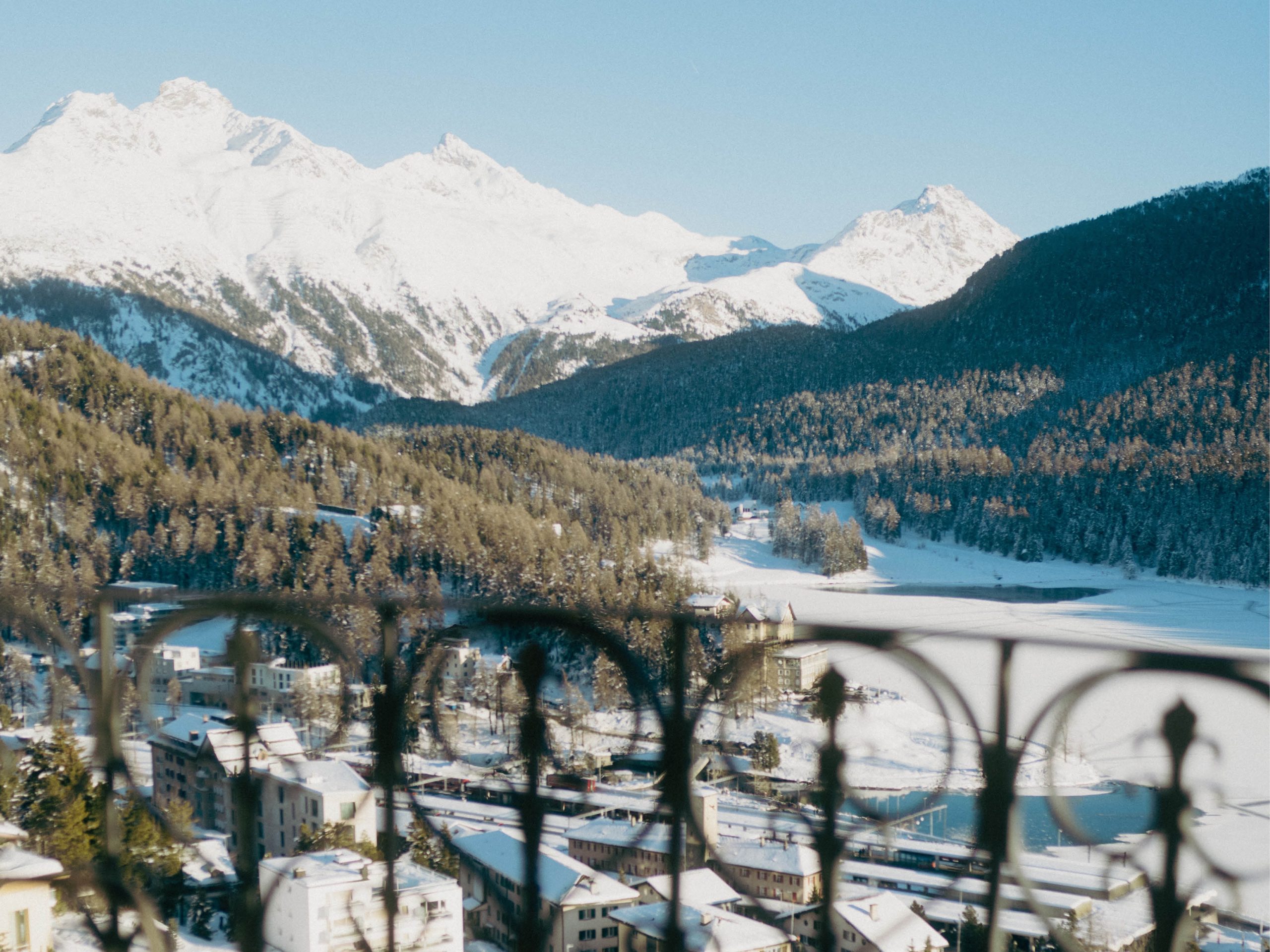 Lake and snow-covered Engadine mountains beyond an ornate balcony, Kulm Hotel St. Moritz, St. Moritz, Switzerland