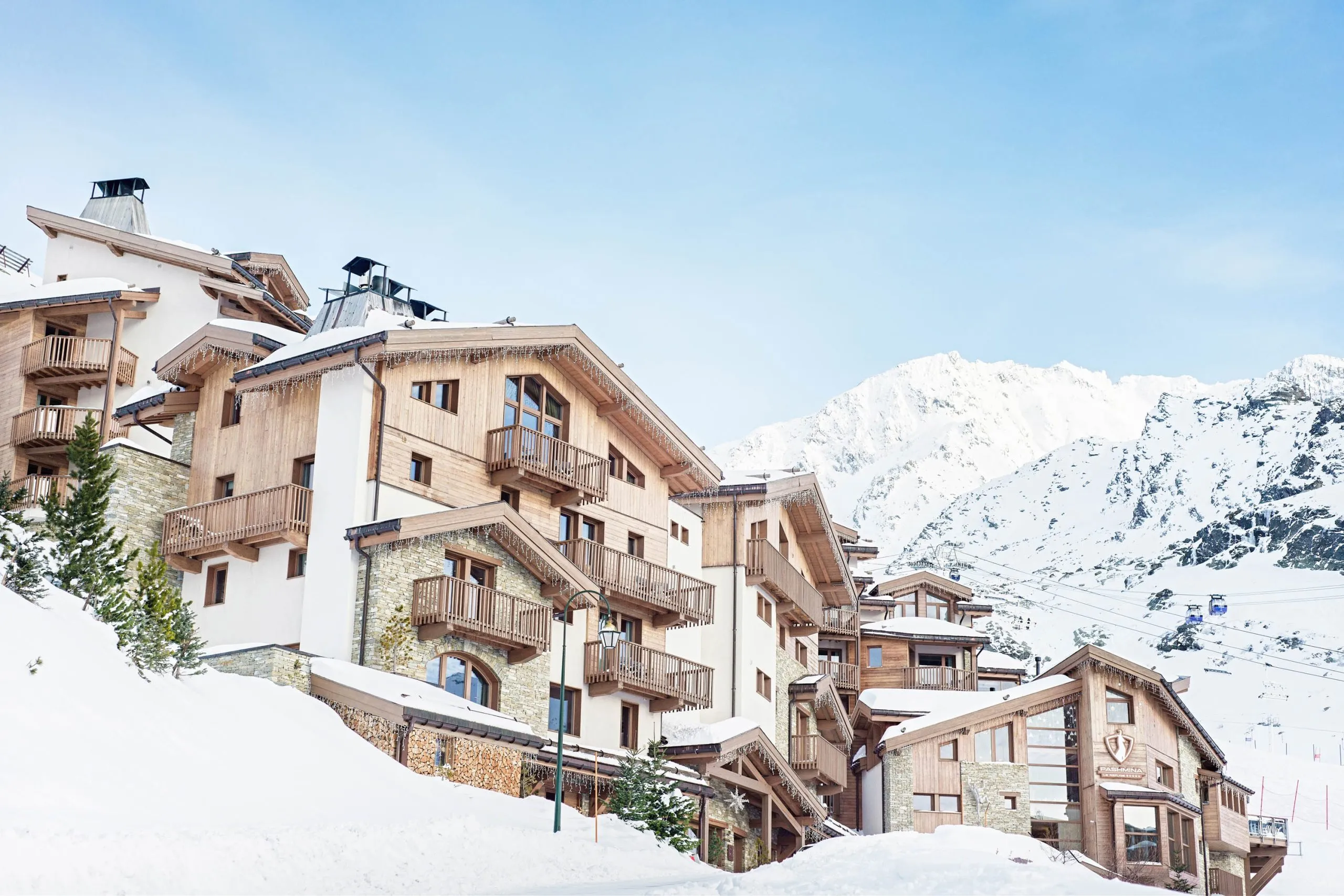 Snow-covered hotel exterior beneath Alpine peaks, Hotel Pashmina Le Refuge, Val Thorens, France