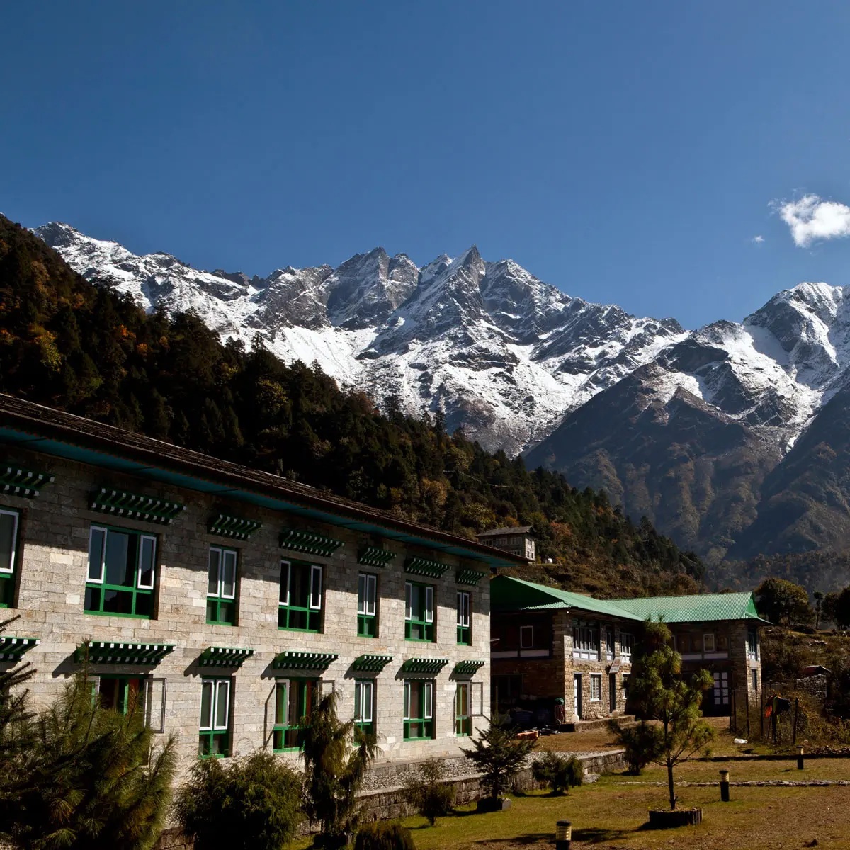Lodge exterior with snow-covered peaks behind it at Yeti Mountain Home, Everest Region (Khumbu), Nepal