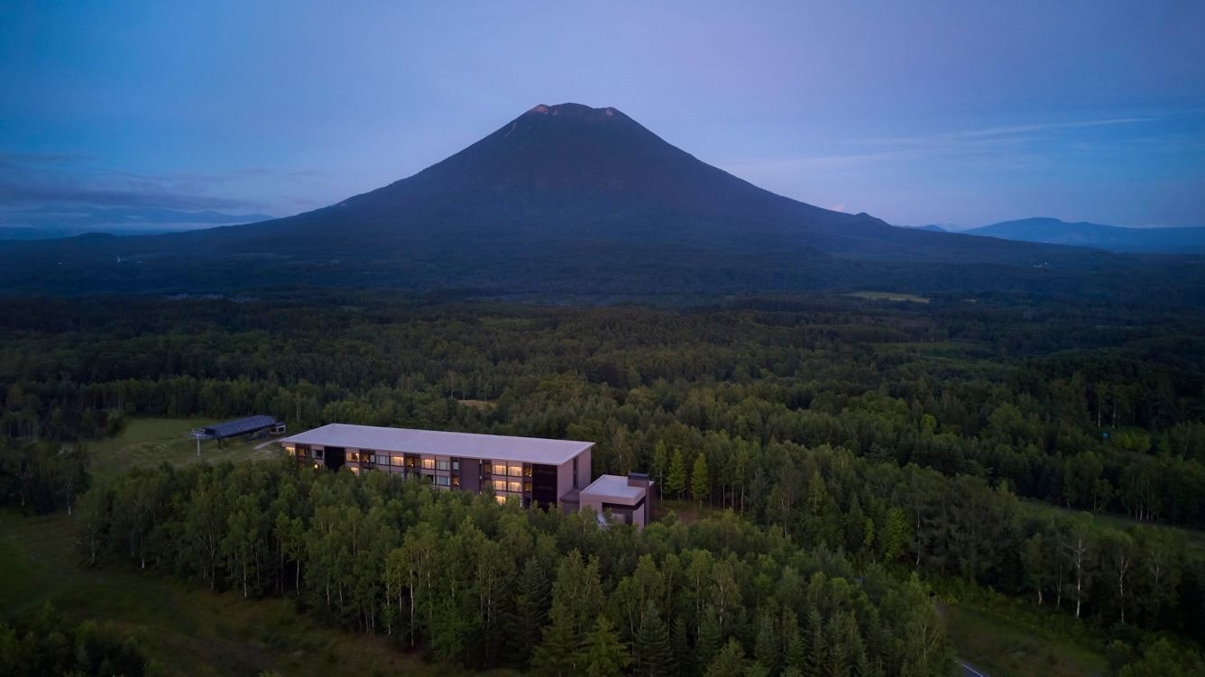 Higashiyama Niseko Village surrounded by green forest beneath the broad cone of Mount Yotei, Higashiyama Niseko Village, a Ritz-Carlton Reserve