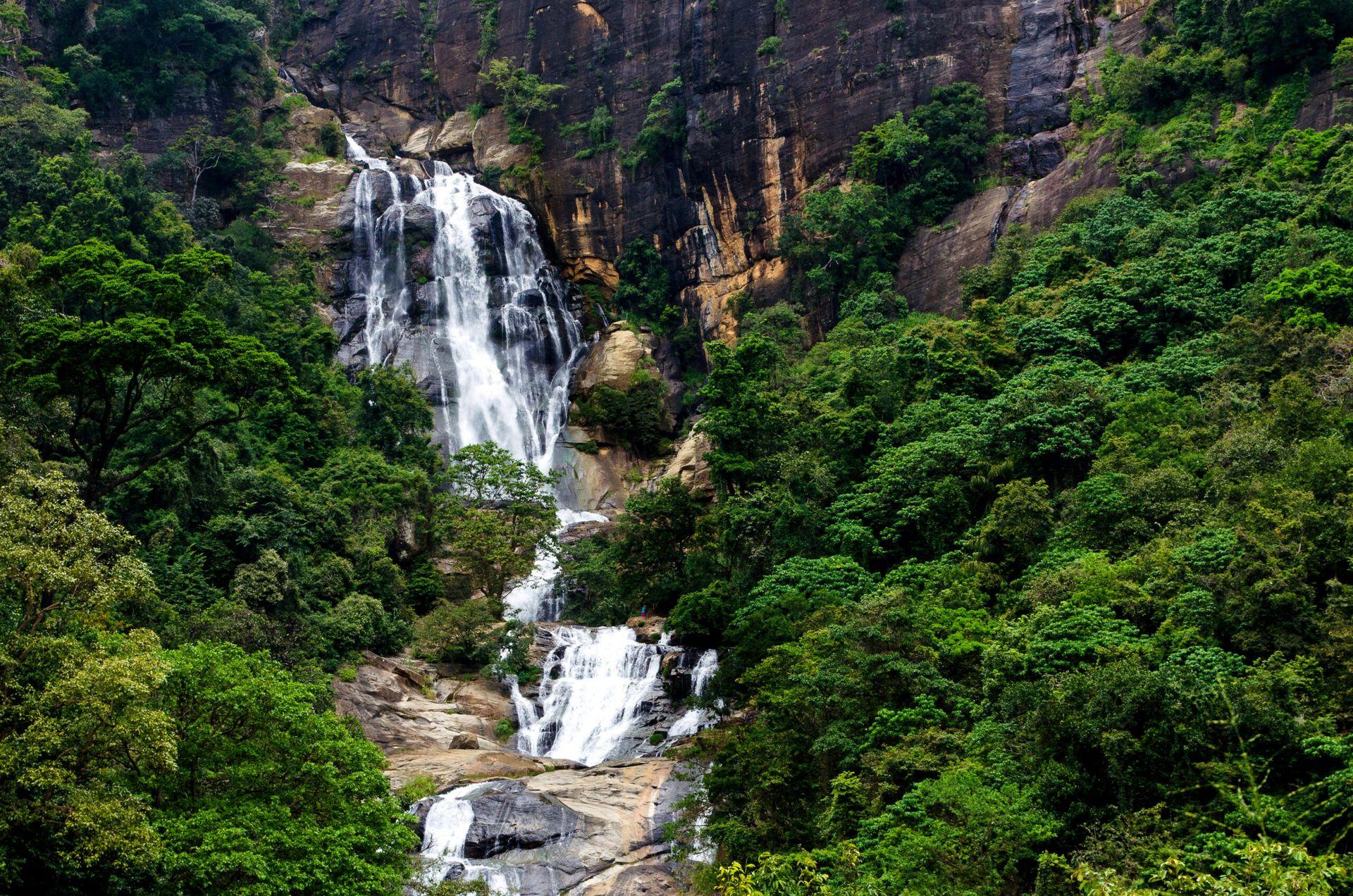 Cascading waterfall descending through lush forest, 98 Acres Resort, Ella, Sri Lanka