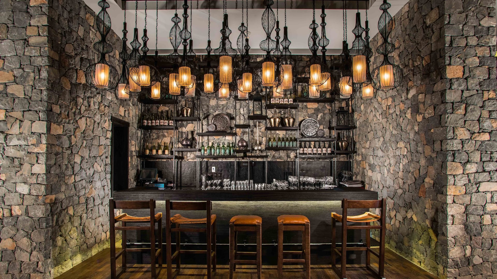 Rose Lounge bar with stone walls, hanging lanterns and bar stools, Alila Jabal Akhdar, Jebel Akhdar, Oman