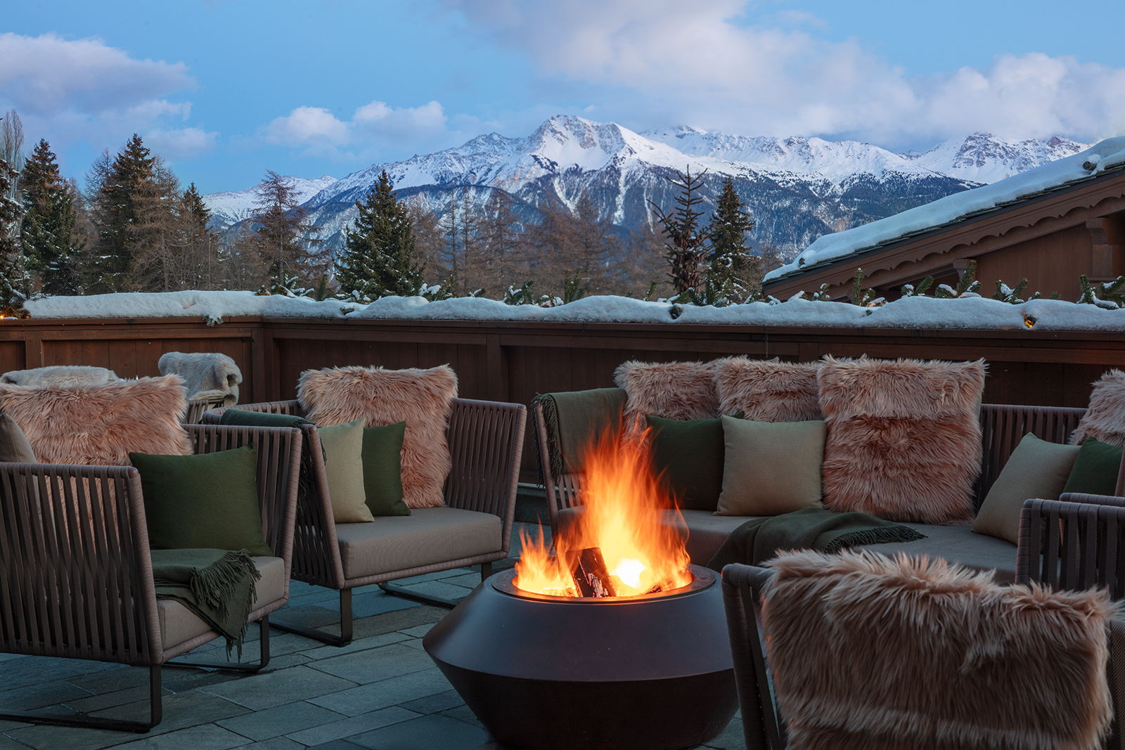 Winter terrace with fire bowl and snowy mountain panorama, Guarda Golf Hotel & Residences, Crans-Montana, Switzerland