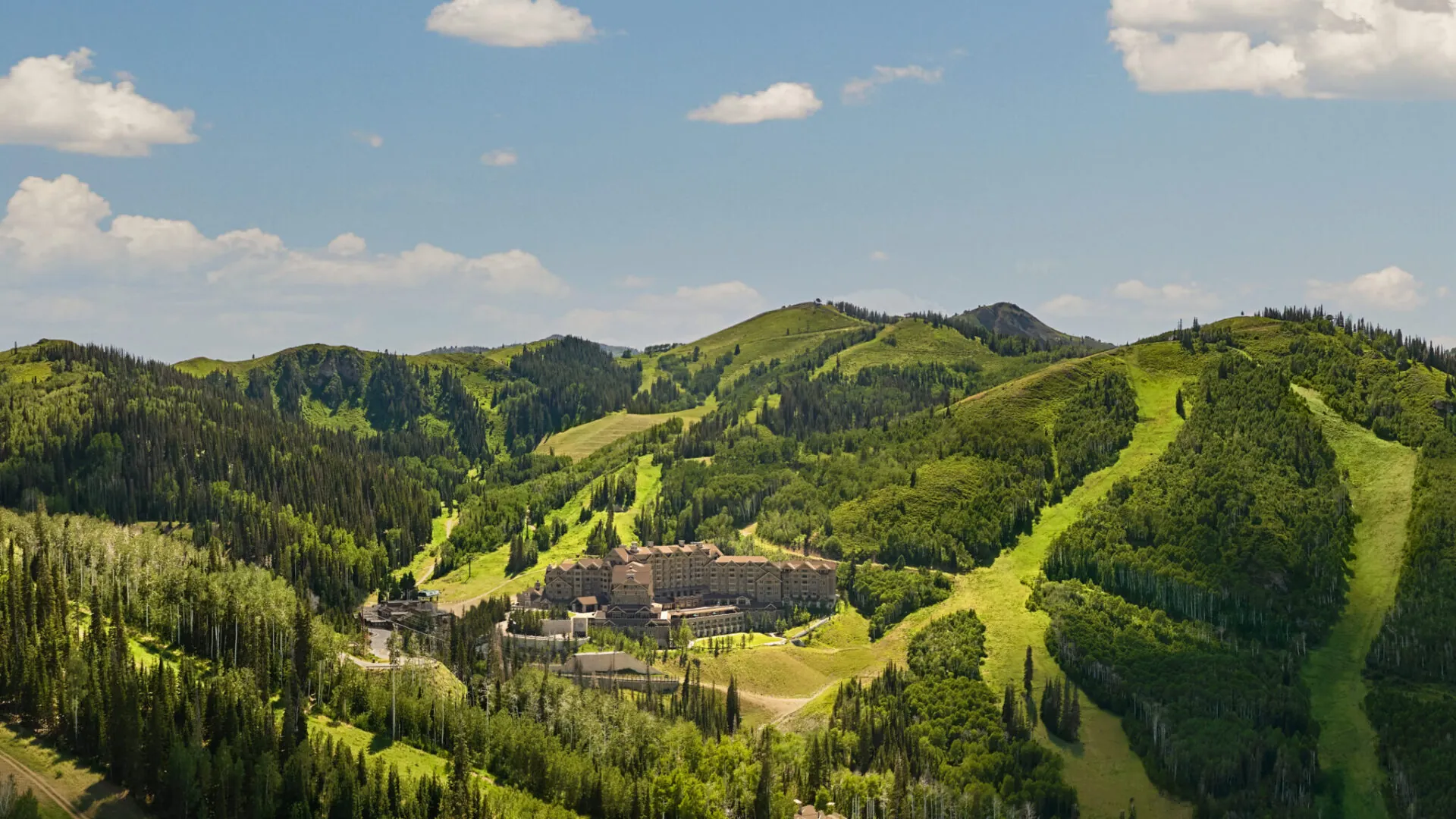 Aerial view of a mountain resort amid green hills at Montage Deer Valley, Utah, USA