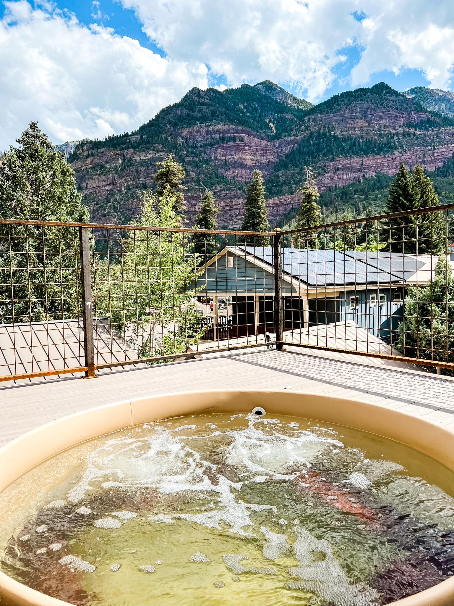 Outdoor mineral soaking tub on a terrace overlooking Ouray mountains at Box Canyon Lodge & Hot Springs, Ouray, USA