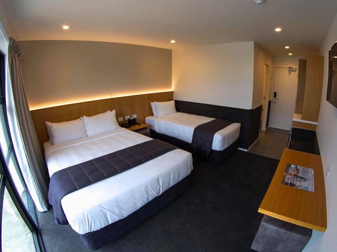 Family room with twin beds and a double bed at The Godley Hotel