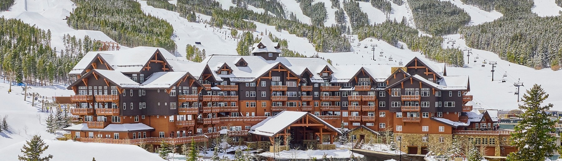 Winter exterior of One Ski Hill Place at the foot of the snow-covered Breckenridge ski slopes.