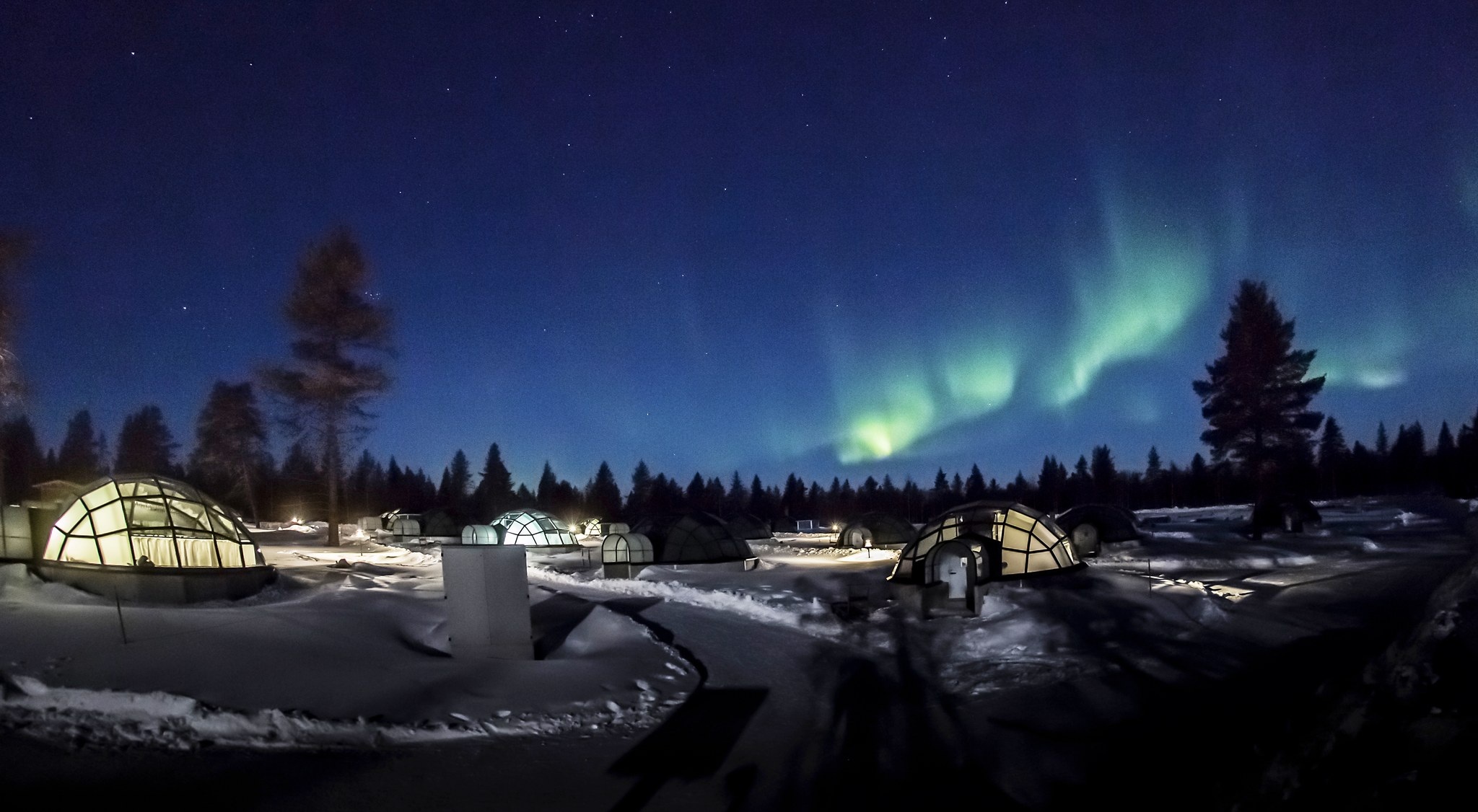 Glass igloos in snow beneath the northern lights at Kakslauttanen Arctic Resort, Saariselkä, Finnish Lapland