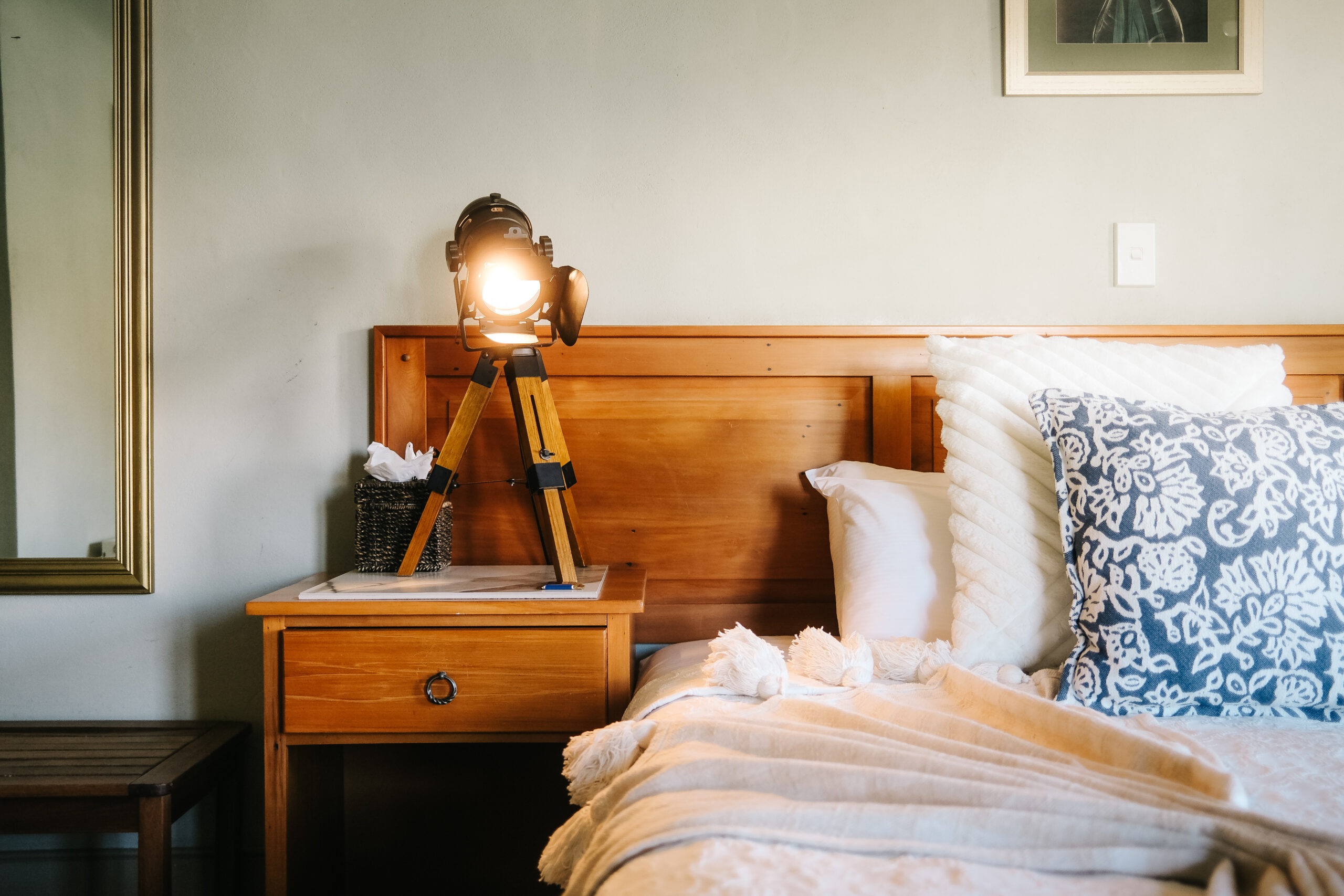 Guest bedroom with wooden headboard and bedside lamp at Browns Boutique Hotel, Queenstown, New Zealand