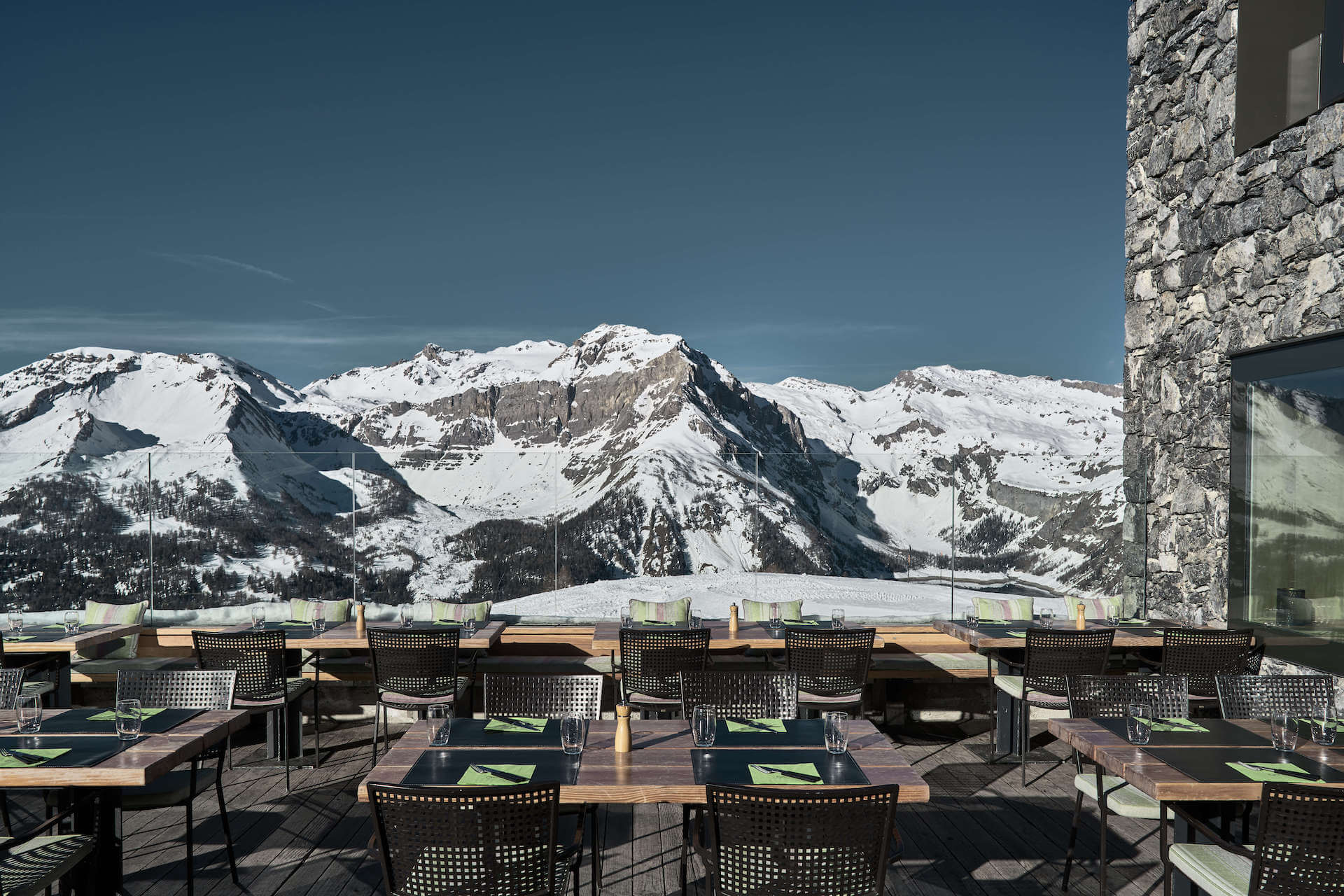 Sunny dining terrace overlooking snow-covered mountains, Chetzeron, Crans-Montana, Switzerland