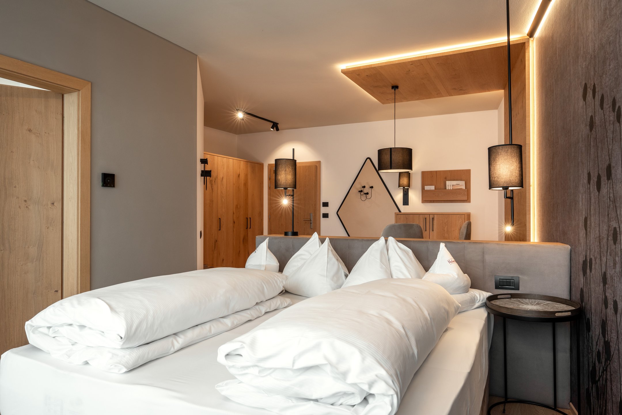 Alpin Panorama Hotel Hubertus guest bedroom with warm wood finishes, Olang, Italy