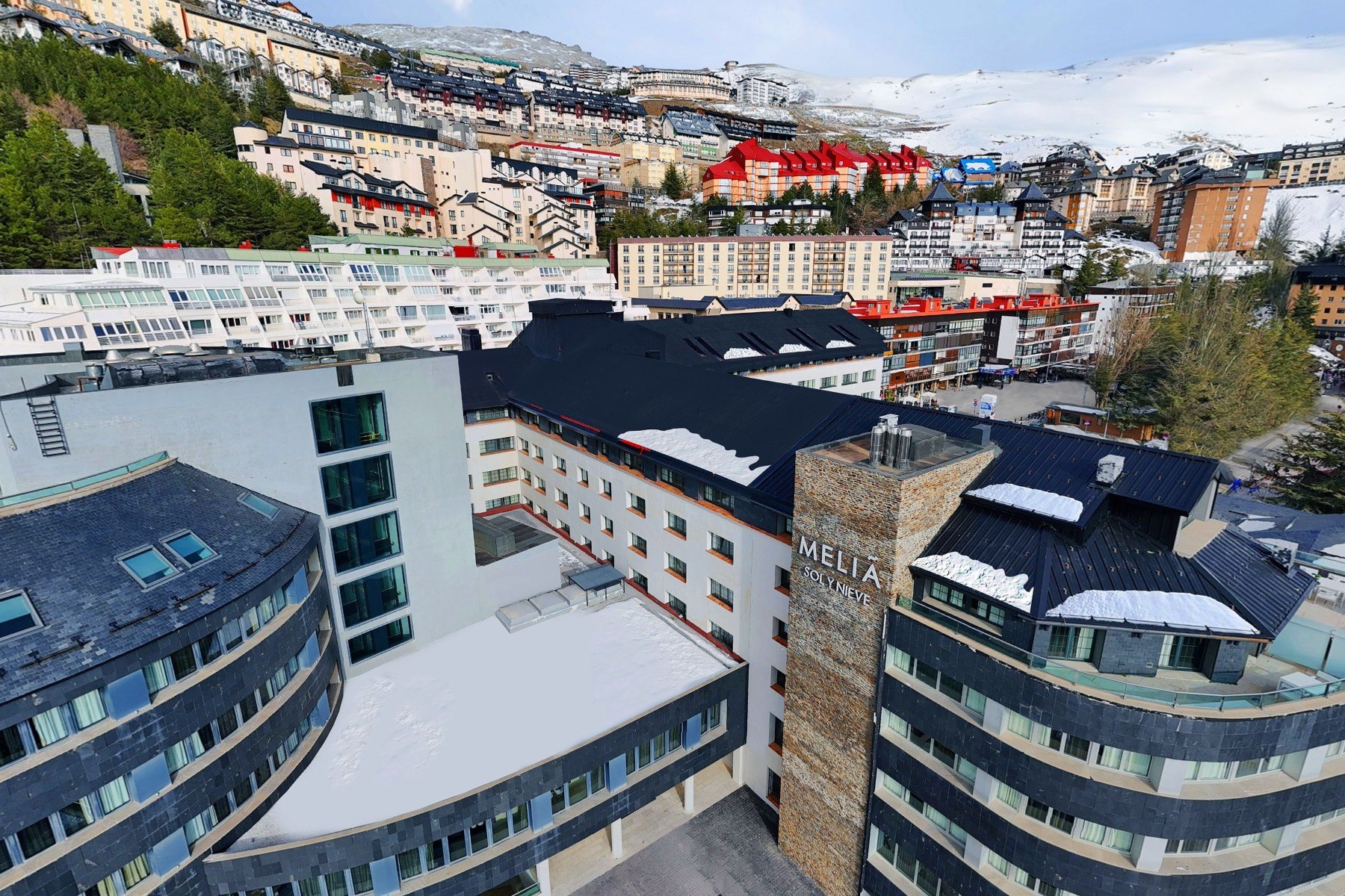 Meliá Sol y Nieve exterior and The Level wing beneath the snowy Sierra Nevada