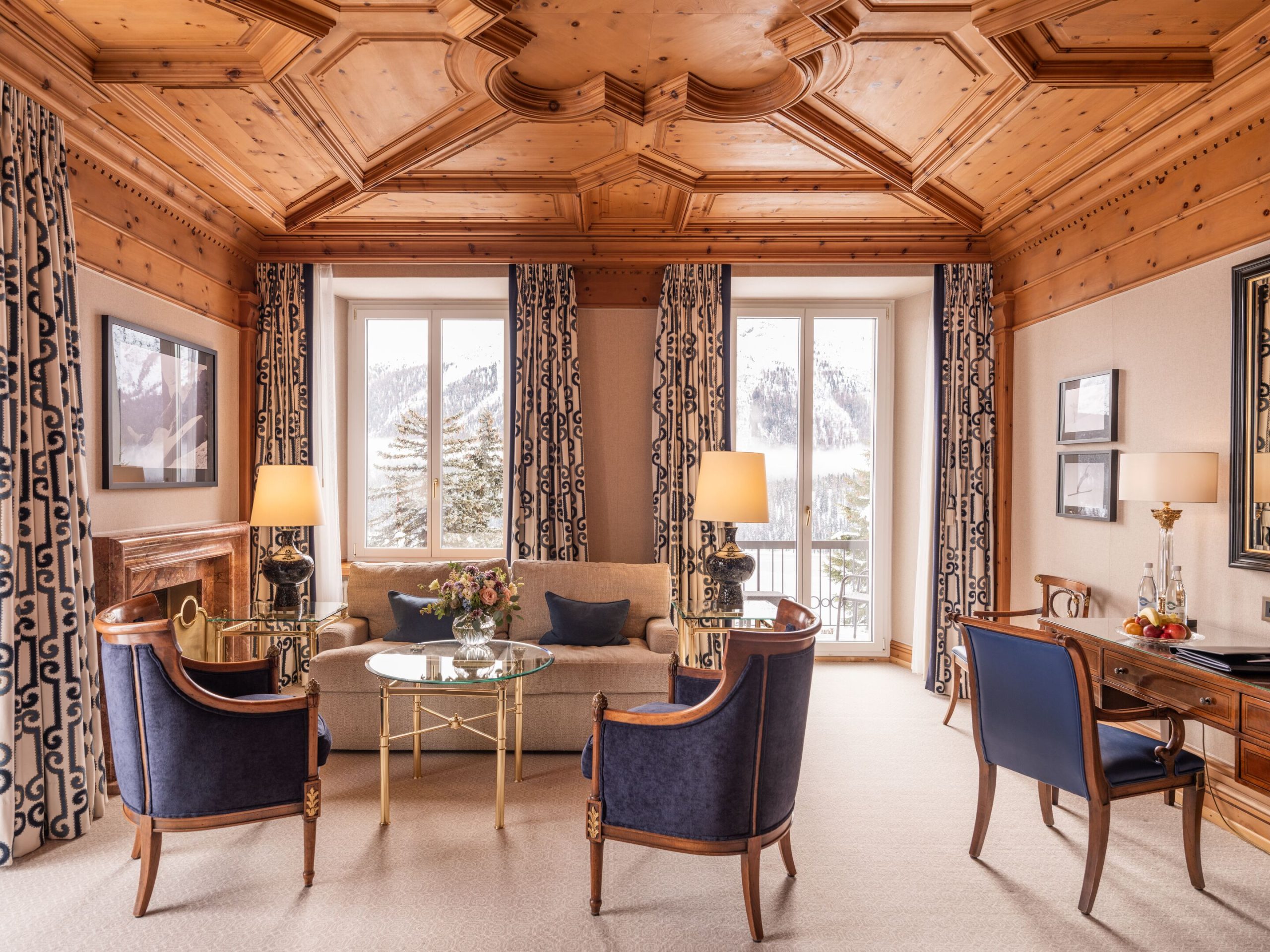 Timber-panelled junior suite sitting area with carved ceiling and lake-facing windows, Kulm Hotel St. Moritz, St. Moritz, Switzerland