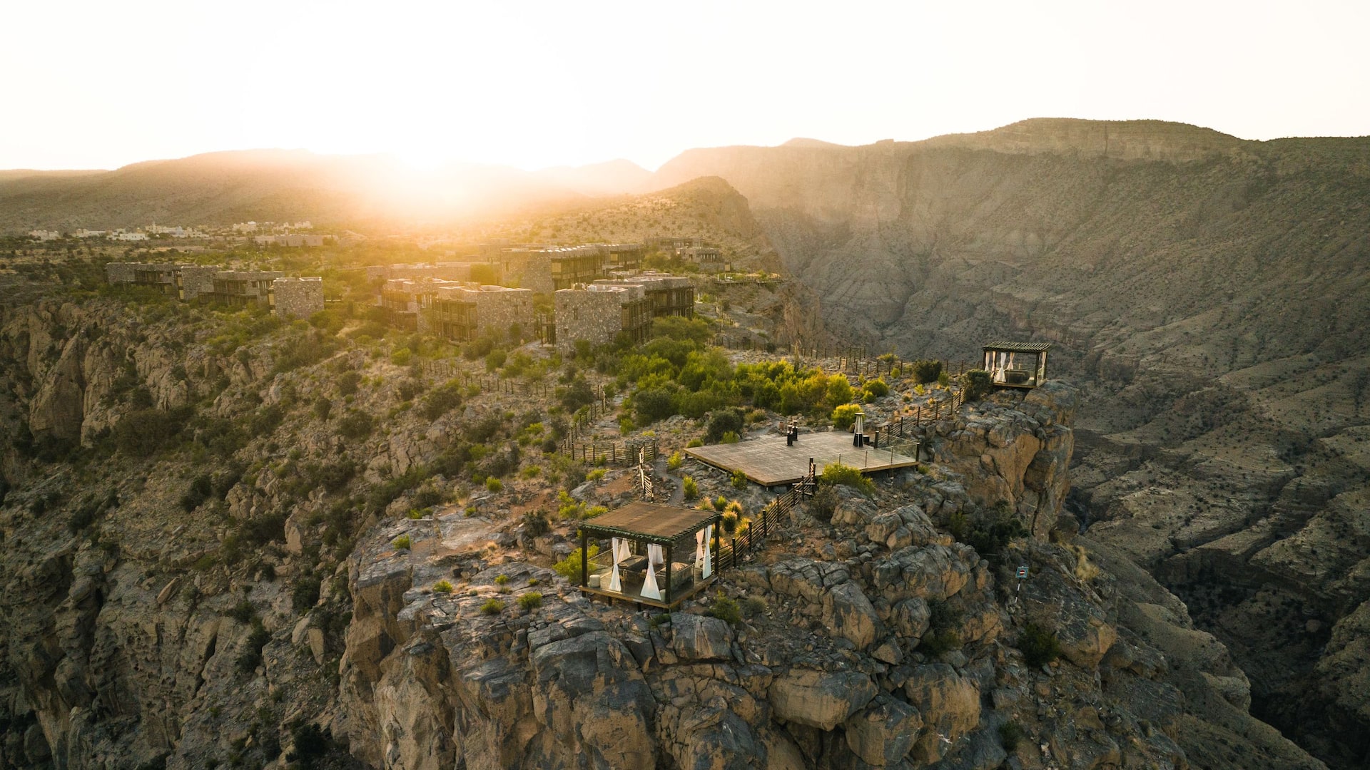 Resort terraces and stone buildings on a dramatic canyon edge at sunset, Alila Jabal Akhdar, Jebel Akhdar, Oman